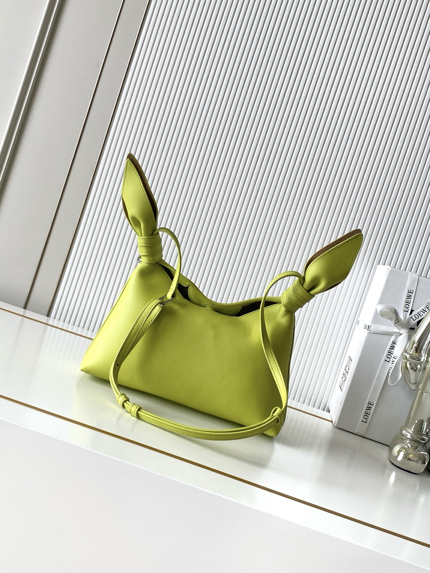 NO:941919,Mini Scarf bag in smooth calfskin The Scarf bag is made from two pieces of fabric, elegantly tied with leather knots and decorated with a new twist. The Pebble signature silhouette is clean, chic and feminine, reminiscent of a knotted scarf. This mini version is made of smooth calfskin *Adjustable leather strap*Can be worn by hand, shoulder or crossbody*Magnetic closure*Suede lining' Engraved Anagram Pebble *L0EWE Hot stamped or silvered  Size 24.5CM～14.5CM～6CM Style No. 9187 Color lemon yellow, Loewe, loewe, cowhide19860909迷你号光滑牛皮革 Scarf 手袋Scarf手袋由两片布料构成透过皮革绳结优雅系合并饰有全新扭曲效果 Pebble 标志廓形简洁别致且充满柔美魅力让人不禁联想到系结围巾. 此迷你号版本采用光滑牛皮革制成*可调节皮革肩带*可手提、肩背或斜挎*磁扣开合*绒面革衬里“镌刻Anagram Pebble *L0EWE 烫金或烫银 尺寸24.5CM～14.5CM～6CM 款号9187 颜色柠檬黄,罗意威,loewe,cowhide,Bag