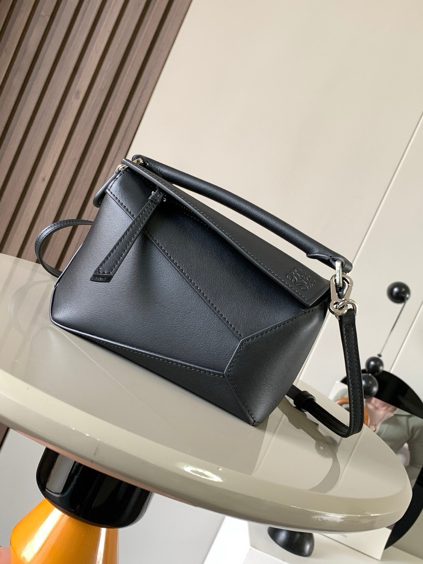 NO:942042,The popular new version of the geometric bag mini 18CM imported Napa calfskin Puzzle handbag is the creative director of Jonathan.  Anderson's first handbag for L0EWE The cuboid shape and precise cutting techniques create the unique geometric lines of the Puzzle. This mini version is crafted from classic cow leather Mini Puzzle  It can accommodate, for example, a small vertical wallet, mobile phones of most sizes (up to 6.1 inches) and sunglasses cases to be carried across the body, on the shoulder, in the hand or by the top handle. The detachable shoulder strap almost ignores the weight of the bag itself, making it practical for carrying mobile phones, small purses, lipsticks and powders when going out, without any sense of cumbersomeness, and a relaxed and happy life starts from now on (the xs and plus you are most concerned about are all OK). Size 18～12.5～8CM, style number 9310～8003  Color black,loewe,loewe,wallets,cowhide19860909爆款新版本几何包迷你18CM原厂进口纳帕小牛皮Puzzle手袋是创意总监乔纳森．安德森为 L0EWE 推出的首款手提包长方体形状和精确的切割技术创造了 Puzzle 独特的几何线条.这个迷你版本采用经典牛皮革制成迷你 Puzzle 可以容纳例如一只小号垂直钱包、大多数尺寸的手机（最大6.1英寸）和太阳镜盒斜挎、肩背、手拿或顶部提手携带.可拆卸肩带包包自身重量几乎忽略,炒鸡实用,出门装手机小钱包口红粉饼,毫无累赘感,轻松愉快人生从此开启(你们最关心的xs,plus都ok哈） 尺寸18～12.5～8CM 款号9310～8003 颜色黑色,罗意威,loewe,wallets,cowhide,Bag