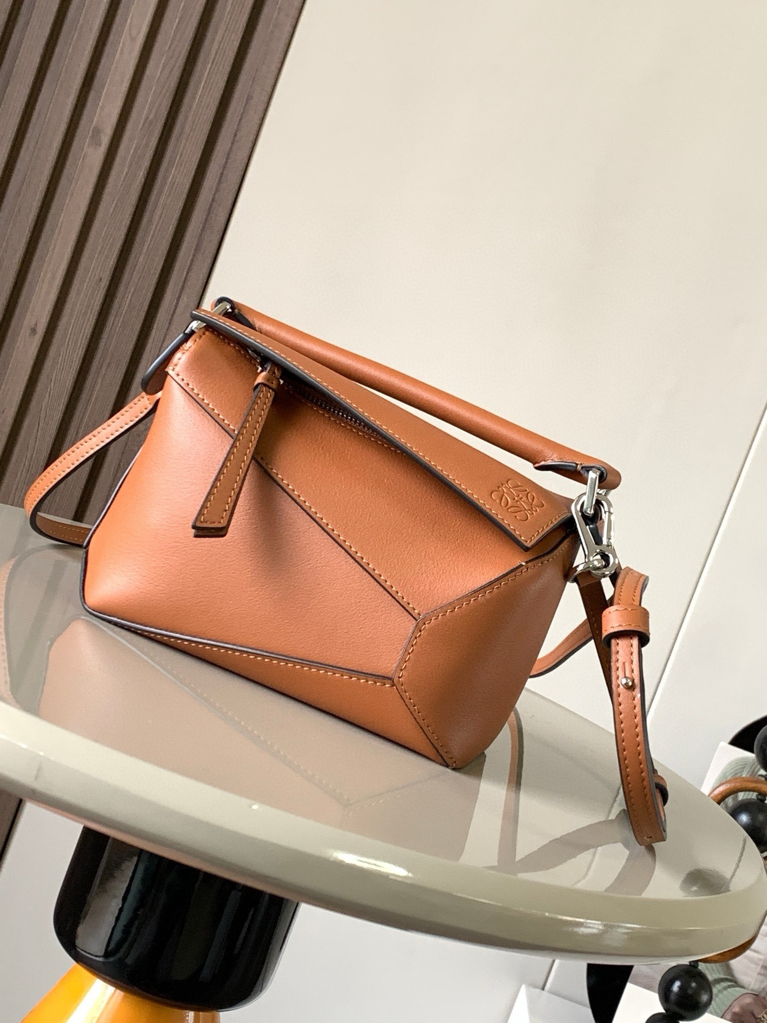 NO:942009,The popular new version of the geometric bag mini 18CM imported Napa calfskin Puzzle handbag is the creative director of Jonathan.  Anderson's first handbag for L0EWE The cuboid shape and precise cutting techniques create the unique geometric lines of the Puzzle. This mini version is crafted from classic cow leather Mini Puzzle  It can accommodate, for example, a small vertical wallet, mobile phones of most sizes (up to 6.1 inches) and sunglasses cases to be carried across the body, on the shoulder, in the hand or by the top handle. The detachable shoulder strap almost ignores the weight of the bag itself, making it practical for carrying mobile phones, small purses, lipsticks and powders when going out, without any sense of cumbersomeness, and a relaxed and happy life starts from now on (the xs and plus you are most concerned about are all OK). Size 18～12.5～8CM, style number 9310～8003  Color brown,loewe,loewe,wallets,cowhide19860909爆款新版本几何包迷你18CM原厂进口纳帕小牛皮Puzzle手袋是创意总监乔纳森．安德森为 L0EWE 推出的首款手提包长方体形状和精确的切割技术创造了 Puzzle 独特的几何线条.这个迷你版本采用经典牛皮革制成迷你 Puzzle 可以容纳例如一只小号垂直钱包、大多数尺寸的手机（最大6.1英寸）和太阳镜盒斜挎、肩背、手拿或顶部提手携带.可拆卸肩带包包自身重量几乎忽略,炒鸡实用,出门装手机小钱包口红粉饼,毫无累赘感,轻松愉快人生从此开启(你们最关心的xs,plus都ok哈） 尺寸18～12.5～8CM 款号9310～8003 颜色棕色,罗意威,loewe,wallets,cowhide,Bag