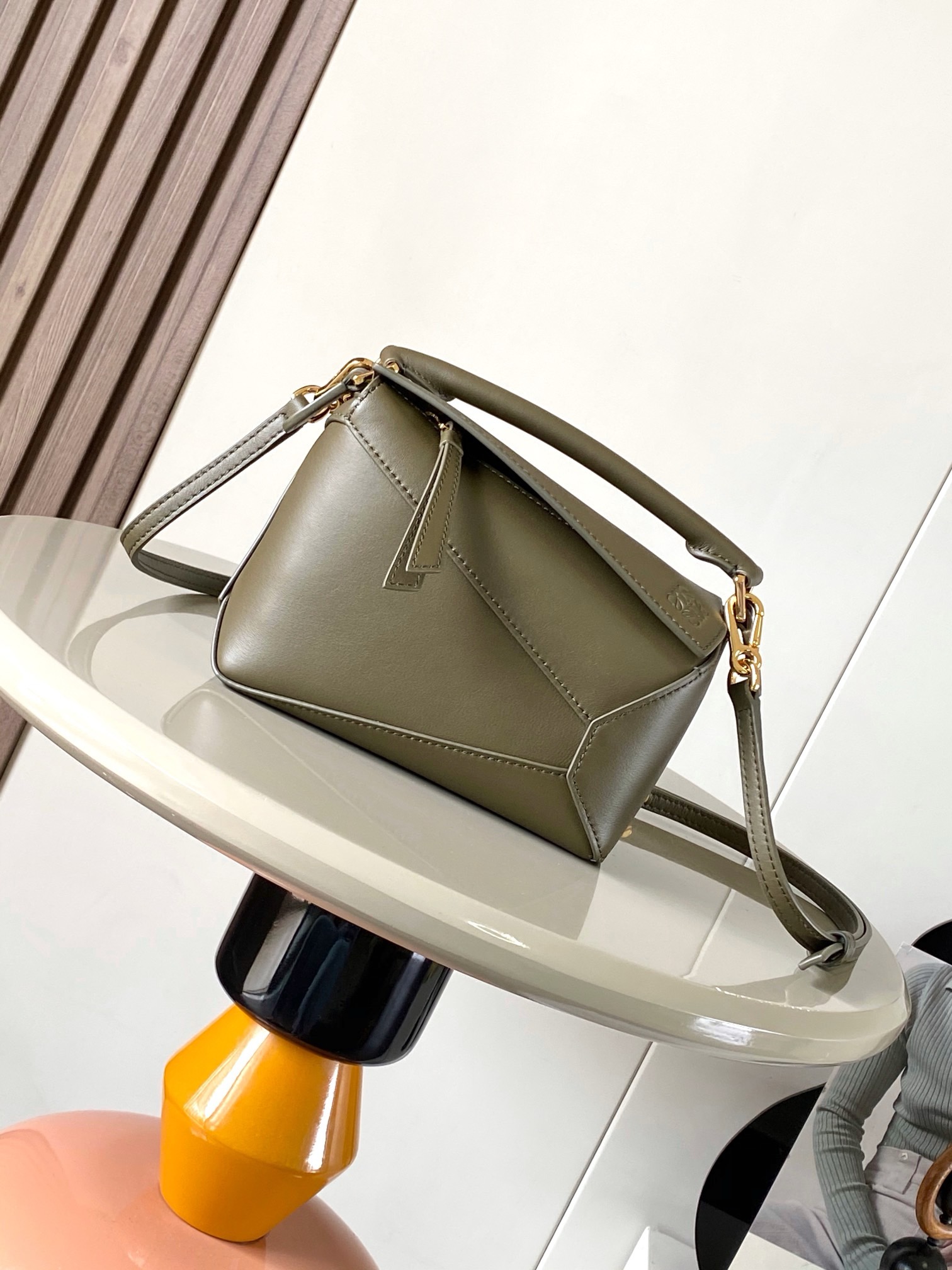 NO:942020,The popular new version of the geometric bag mini 18CM imported Napa calfskin Puzzle handbag is the creative director of Jonathan.  Anderson's first handbag for L0EWE The cuboid shape and precise cutting techniques create the unique geometric lines of the Puzzle. This mini version is crafted from classic cow leather Mini Puzzle  It can accommodate, for example, a small vertical wallet, mobile phones of most sizes (up to 6.1 inches) and sunglasses cases to be carried across the body, on the shoulder, in the hand or by the top handle. The detachable shoulder strap almost ignores the weight of the bag itself, making it practical for carrying mobile phones, small purses, lipsticks and powders when going out, without any sense of cumbersomeness, and a relaxed and happy life starts from now on (the xs and plus you are most concerned about are all OK). Size 18～12.5～8CM, style number 9310～8003  Color khaki green,loewe,loewe,wallets,cowhide19860909爆款新版本几何包迷你18CM原厂进口纳帕小牛皮Puzzle手袋是创意总监乔纳森．安德森为 L0EWE 推出的首款手提包长方体形状和精确的切割技术创造了 Puzzle 独特的几何线条.这个迷你版本采用经典牛皮革制成迷你 Puzzle 可以容纳例如一只小号垂直钱包、大多数尺寸的手机（最大6.1英寸）和太阳镜盒斜挎、肩背、手拿或顶部提手携带.可拆卸肩带包包自身重量几乎忽略,炒鸡实用,出门装手机小钱包口红粉饼,毫无累赘感,轻松愉快人生从此开启(你们最关心的xs,plus都ok哈） 尺寸18～12.5～8CM 款号9310～8003 颜色卡其绿,罗意威,loewe,wallets,cowhide,Bag
