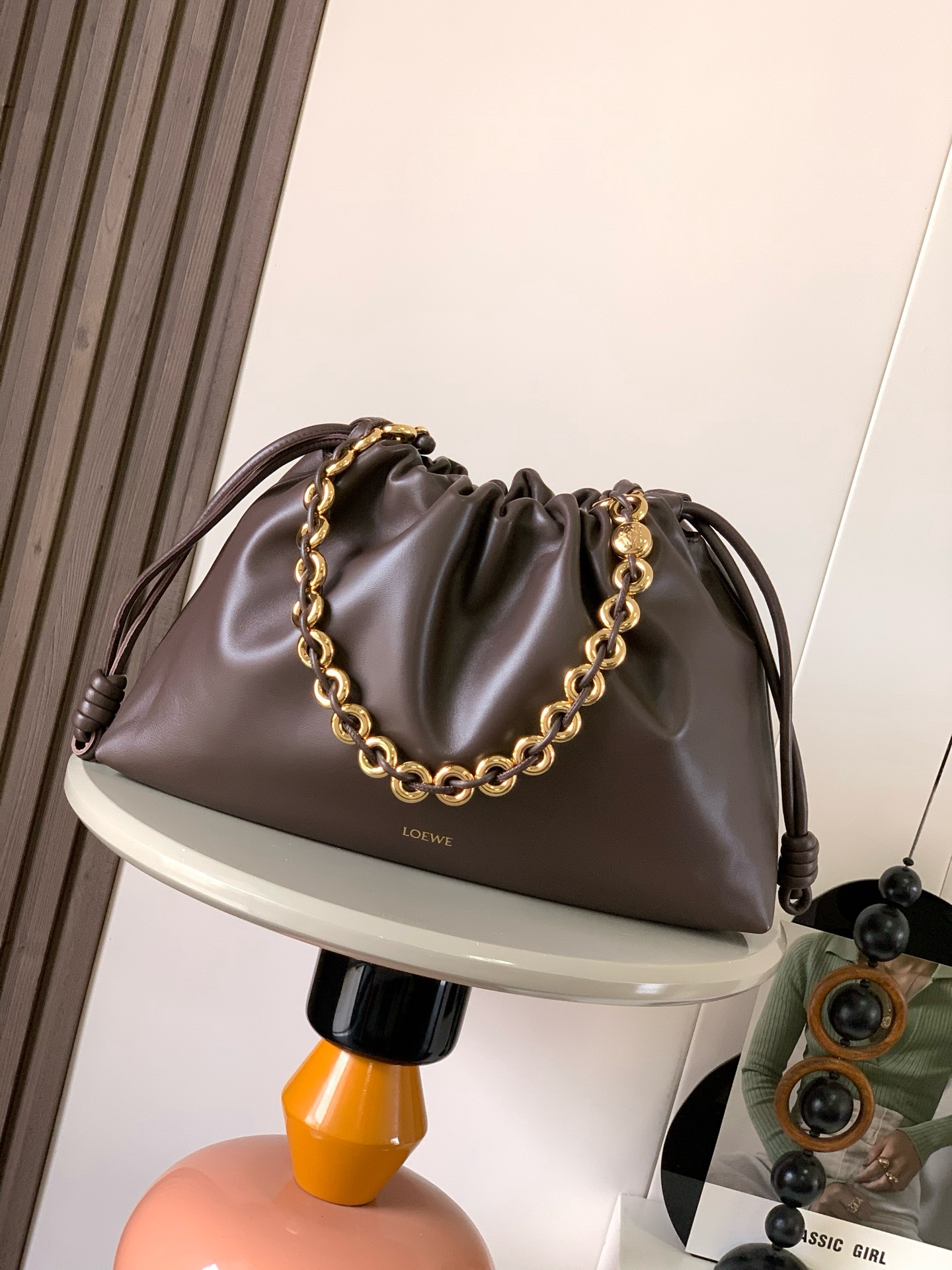 NO:942023,The star of the new product is the same large soft nappa sheep leather Flamenco Purse clutch. The Flamenco Purse clutch adopts a pleated design, inspired by the aesthetics of the Flamenco series. Key details such as the iconic knots and donut chains on both sides are reinterpreted in a wider proportion. This large version is made of soft nappa sheep leather with tone-on-tone metal hardware.  Pebble *Exquisite magnetic buckle closure19860909新品明星同款大号柔软纳帕羊皮革 Flamenco Purse手拿包Flamenco Purse 手拿包采用褶皱设计,灵感来自 Flamenco 系列美学,主要细节如两侧的标志性绳结和甜甜圈链条以更加宽大的比例重新演绎.此大号版本采用柔软纳帕羊皮革制成搭配同色系金属配件＊可肩背、斜挎或手提＊可拆卸可调节皮革肩带＊可拆卸甜甜圈链条饰以 Anagram Pebble ＊精妙磁扣开合＊绒面革衬里＊ LOEWE 烫金 颜色布朗尼深棕 尺寸41cm～9cm～26cm 款号9088,罗意威,thom browne,loewe,loewe,handbag,sheepskin,Bag