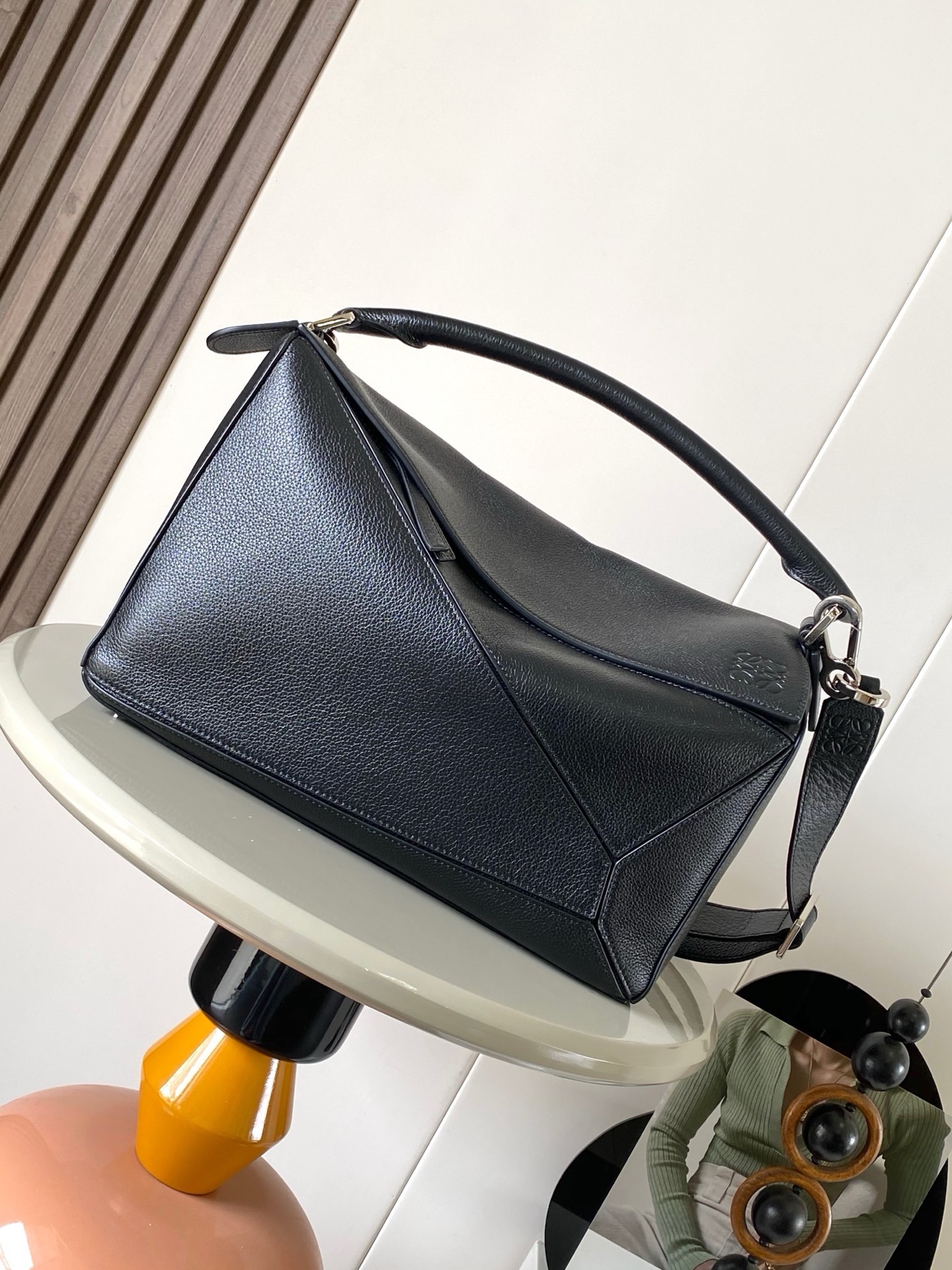 NO:942035,The new Puzzle size handbag Puzzle handbag is the creative director of Jonathan.  Jonathan Anderson created Puzzle for LOEWE's first handbag with its rectangular shape and precise cutting techniques  Unique geometric lines This version is made of glossy cow leather with overlapping edges * Can be worn on the shoulder, cross-body or by hand * Detachable and adjustable shoulder strap * External rear zip pocket and two internal slip pockets * Zipper closure cow leather zipper pull * Can be customized with shoulder straps and personalized charms * Suede lining * Anagram embossing Suitable for different occasions Unisex  Size 33cm～14.7cm～21.5cm Style number 9095 Color black, Loewe, loewe, loewe, cowhide19860909新款Puzzle尺寸手袋Puzzle 手袋是创意总监乔纳森．安德森（ Jonathan Anderson）为 LOEWE 推出的首款手提包长方体形状和精确的切割技术创造了 Puzzle 独特的几何线条此版本采用亮面牛皮革制成饰有重叠边缘＊可肩背、斜挎或手提＊可拆卸可调节肩带＊外部后方拉链袋和两个内部插袋＊拉链开合牛皮革拉链头＊可以使用肩带和个性化挂饰进行定制＊绒面革衬里＊ Anagram 压纹 满足不同场合需求男女通用 尺寸33cm～14.7cm～21.5cm 款号9095 颜色黑色,罗意威,loewe,loewe,cowhide,Bag