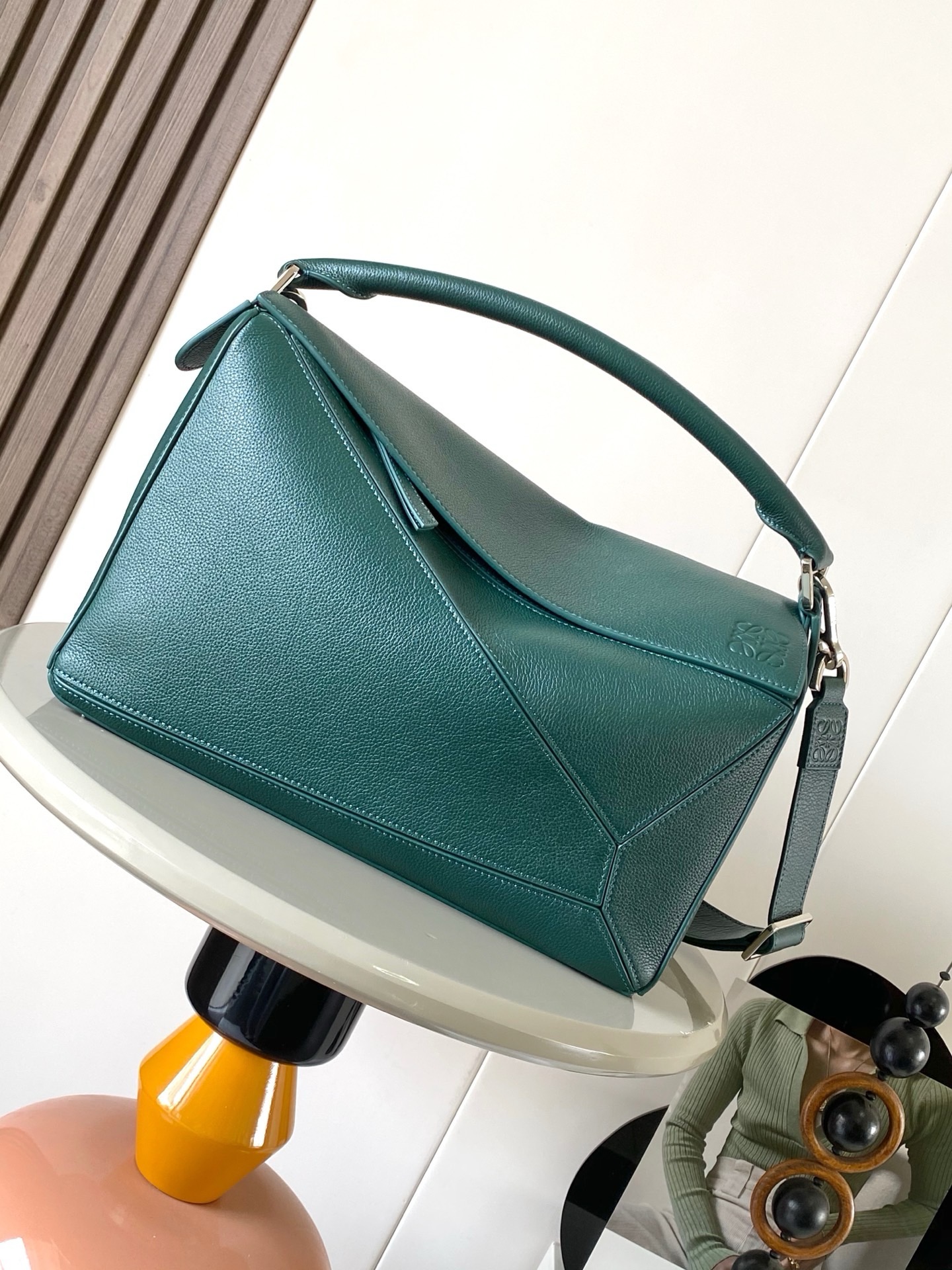 NO:942039,The new Puzzle size handbag Puzzle handbag is the creative director of Jonathan.  Jonathan Anderson created Puzzle for LOEWE's first handbag with its rectangular shape and precise cutting techniques  Unique geometric lines This version is made of glossy cow leather with overlapping edges * Can be worn on the shoulder, cross-body or by hand * Detachable and adjustable shoulder strap * External rear zip pocket and two internal slip pockets * Zipper closure cow leather zipper pull * Can be customized with shoulder straps and personalized charms * Suede lining * Anagram embossing Suitable for different occasions Unisex  Size 33cm～14.7cm～21.5cm Style number 9095 Color evergreen, Loewe, loewe, loewe, cowhide19860909新款Puzzle尺寸手袋Puzzle 手袋是创意总监乔纳森．安德森（ Jonathan Anderson）为 LOEWE 推出的首款手提包长方体形状和精确的切割技术创造了 Puzzle 独特的几何线条此版本采用亮面牛皮革制成饰有重叠边缘＊可肩背、斜挎或手提＊可拆卸可调节肩带＊外部后方拉链袋和两个内部插袋＊拉链开合牛皮革拉链头＊可以使用肩带和个性化挂饰进行定制＊绒面革衬里＊ Anagram 压纹 满足不同场合需求男女通用 尺寸33cm～14.7cm～21.5cm 款号9095 颜色常青绿,罗意威,loewe,loewe,cowhide,Bag