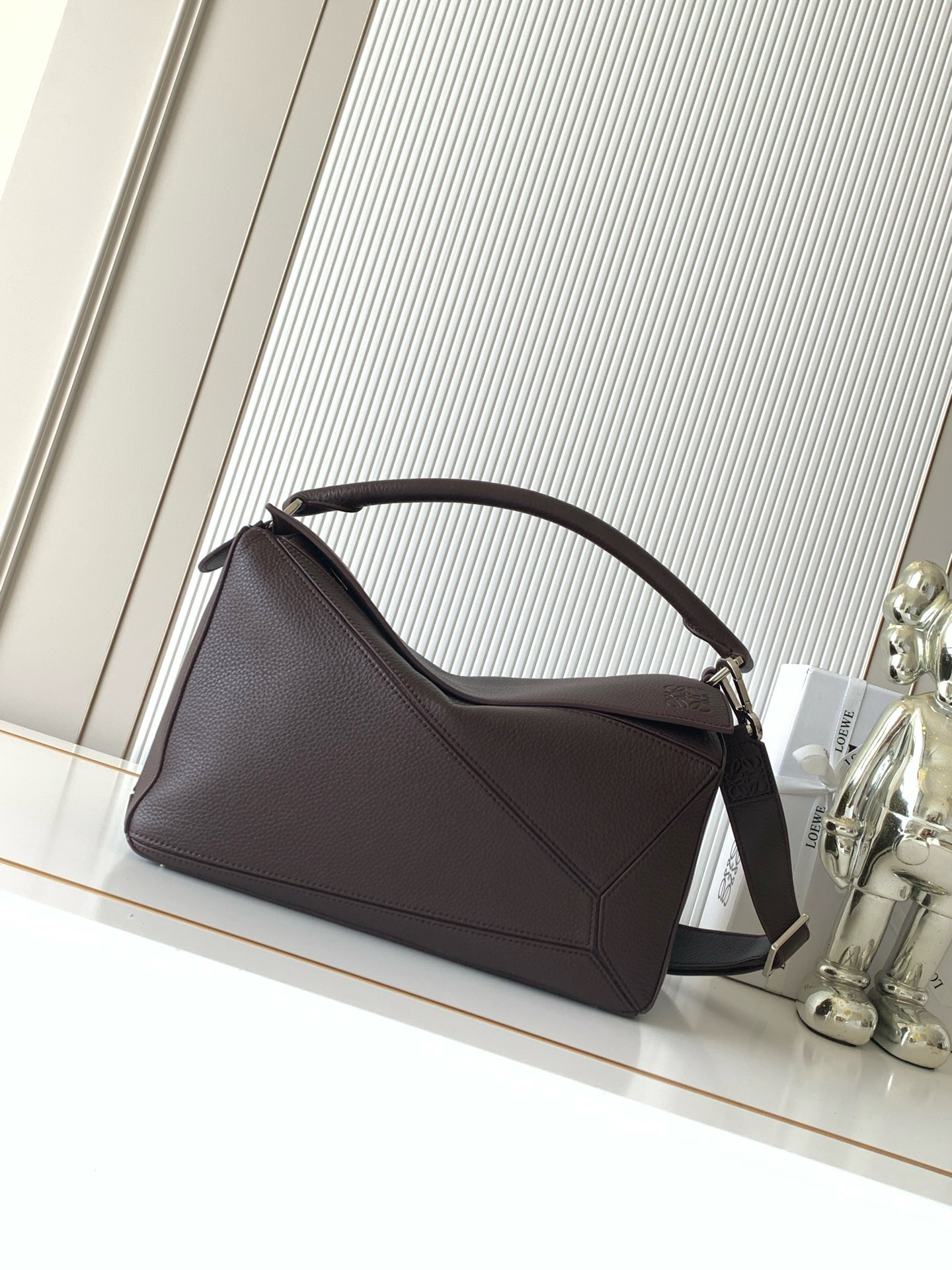 NO:942060,The new Puzzle size handbag Puzzle handbag is the creative director of Jonathan.  The first handbag launched by Jonathan Anderson, the cuboid shape and precise cutting techniques create the unique geometric lines of the Puzzle. This version is made from glossy cow leather with overlapping edges. * Can be worn on the shoulder, cross-body or handheld.  Anagram embossing to meet the needs of different occasions, unisex, size 33cm～14.7cm～21.5cm, style number 9095, color chocolate/deerskin, Loewe, loewe, cowhide19860909新款Puzzle尺寸手袋Puzzle 手袋是创意总监乔纳森．安德森（ Jonathan Anderson）推出的首款手提包长方体形状和精确的切割技术创造了 Puzzle 独特的几何线条此版本采用亮面牛皮革制成饰有重叠边缘＊可肩背、斜挎或手提＊可拆卸可调节肩带＊外部后方拉链袋和两个内部插袋＊拉链开合牛皮革拉链头＊可以使用肩带和个性化挂饰进行定制＊绒面革衬里＊ Anagram 压纹 满足不同场合需求男女通用 尺寸33cm～14.7cm～21.5cm 款号9095 颜色巧克力/鹿皮,罗意威,loewe,cowhide,Bag