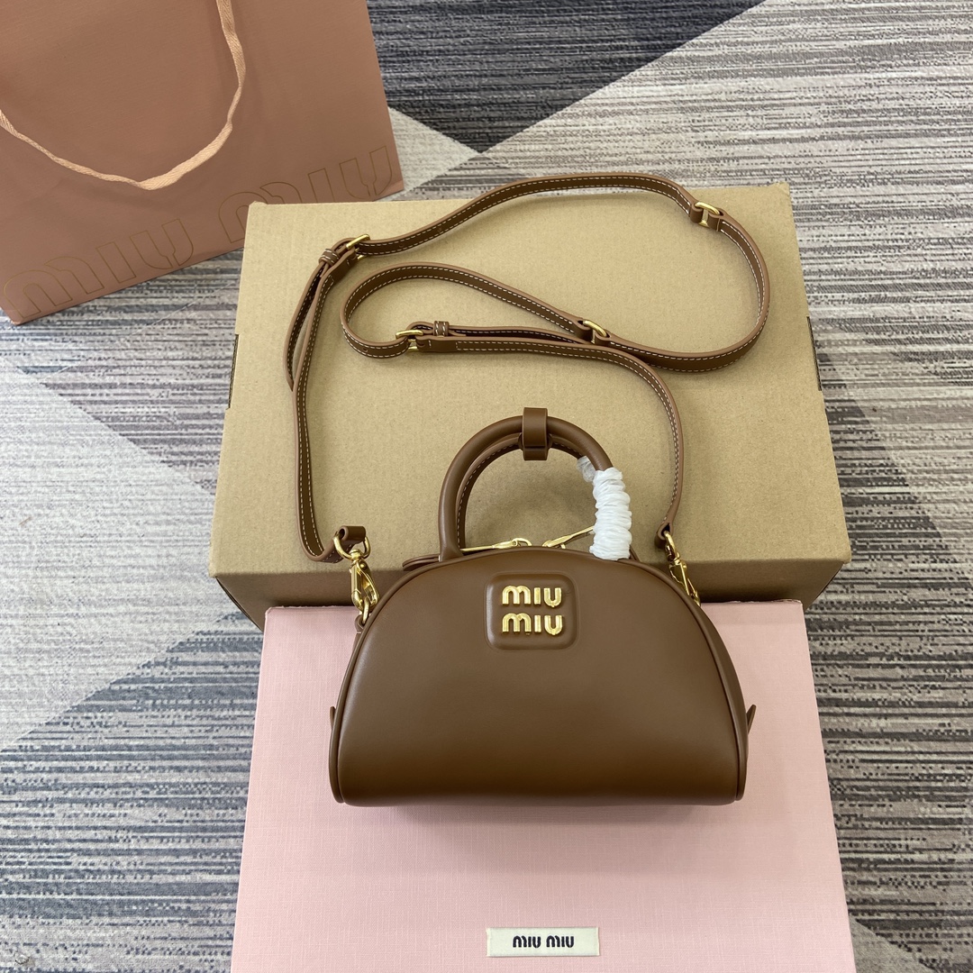 配全套专柜包装】‼️Miu家秀款饺子包,官网主推,今年绝对爆🔥款式,采用顶级进口小牛皮,时尚半圆设计,包身精致立体有型,风格百变,适配度很高,日常出行怎么搭都好看,正面标志性金属logo标,可拆卸可调节皮革长肩带,棉质缎面衬里,小号是精致的小可爱 型号:5BC085。 尺寸:18X11.5X8Cm 颜色:棕色全皮。 意大利创作