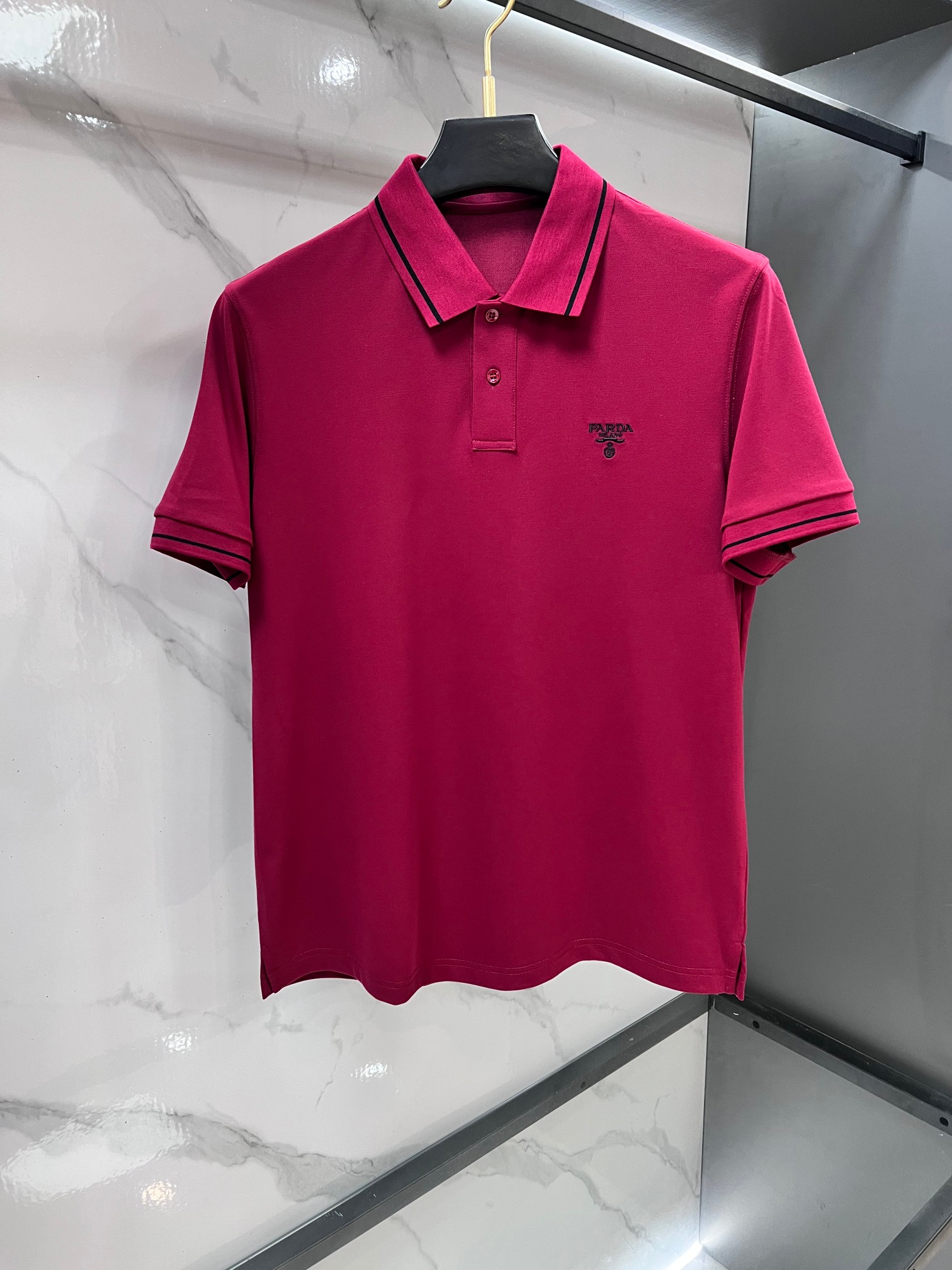 NO:777770,Prada 2026ss summer counter new men's lapel Polo shirt!  The ceiling-level business men's style of high-end men's clothing!  Simple and fashionable yet elegant, it looks great when worn alone, and quality control/details control can be taken away with your eyes closed. It is low-key, luxurious and connotative!  The custom-woven mesh pique cotton fabric supplied by the customer is carefully made. The mesh texture is evenly arranged on the surface of the fabric. It has excellent breathability and heat dissipation and perspiration. The upper body comfort is completely better than ordinary single-sided jersey tissue!  The classic brand LOGO on the chest is made with top-notch craftsmanship. The LOGO is three-dimensional, clear and full, and has extraordinary texture. Whether it is worn as an inner layer or worn alone, it is a classic product!  The exquisite tailoring process, every detail is handled very standard and delicately, which cannot be compared with other low-end products on the market. It is a must-have basic and versatile Polo shirt for men!  …………………………………………………… SizeM-XXXL,,prada,19860909普拉达 2026ss夏季专柜新款男士翻领Polo衫！高端男装的天花板级别的商务男款！简约时尚大气不失优雅,单穿内搭体面过人,品质控/细节控的闭眼带走,低调又奢华有内涵！客供定织网眼珠地棉布精心制成,面料表面排列均匀整齐的网眼纹理,透气性和散热排汗性极佳,上身舒适程度完全优于普通单面汗布组织！胸前经典的品牌LOGO标识,采用顶级工艺打造,LOGO立体清晰饱满,质感非凡的特质,无论是内搭还是单穿都是一款经典领域的产品！精妙绝伦的裁剪工艺,每一个细节处理的非常标准细腻,非市面一般LOW货可以媲美的,男士必入基础百搭款Polo衫推荐！…………………………………………………… SizeM-XXXL,,prada,,Men's clothing