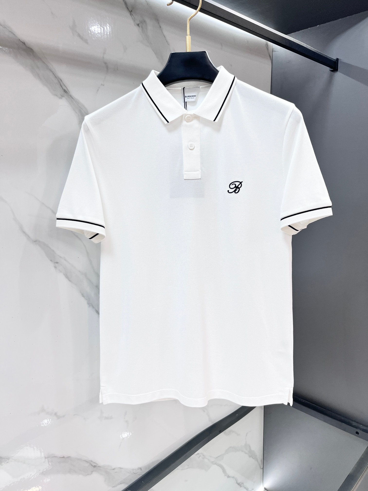 NO:846941,Burberry 2026ss summer counter new men's lapel polo shirt!  The ceiling-level business men's style of high-end men's clothing!  Simple and fashionable yet elegant, it looks great when worn alone, and quality control/details control can be taken away with your eyes closed. It is low-key, luxurious and connotative!  The custom-woven mesh pique cotton fabric supplied by the customer is carefully made. The mesh texture is evenly arranged on the surface of the fabric. It has excellent breathability and heat dissipation and perspiration. The upper body comfort is completely better than ordinary single-sided jersey tissue!  The classic brand LOGO on the chest is made with top-notch craftsmanship. The LOGO is three-dimensional, clear and full, and has extraordinary texture. Whether it is worn as an inner layer or worn alone, it is a classic product!  The exquisite tailoring process, every detail is handled very standard and delicately, which cannot be compared with other low-end products on the market. It is a must-have basic and versatile Polo shirt for men!  ……………………………………………………………… SizeM-XXXXL,,burberry,19860909巴宝莉 2026ss夏季专柜新款男士翻领Polo衫！高端男装的天花板级别的商务男款！简约时尚大气不失优雅,单穿内搭体面过人,品质控/细节控的闭眼带走,低调又奢华有内涵！客供定织网眼珠地棉布精心制成,面料表面排列均匀整齐的网眼纹理,透气性和散热排汗性极佳,上身舒适程度完全优于普通单面汗布组织！胸前经典的品牌LOGO标识,采用顶级工艺打造,LOGO立体清晰饱满,质感非凡的特质,无论是内搭还是单穿都是一款经典领域的产品！精妙绝伦的裁剪工艺,每一个细节处理的非常标准细腻,非市面一般LOW货可以媲美的,男士必入基础百搭款Polo衫推荐！…………………………………………………… SizeM-XXXXL,,burberry,,Men's clothing