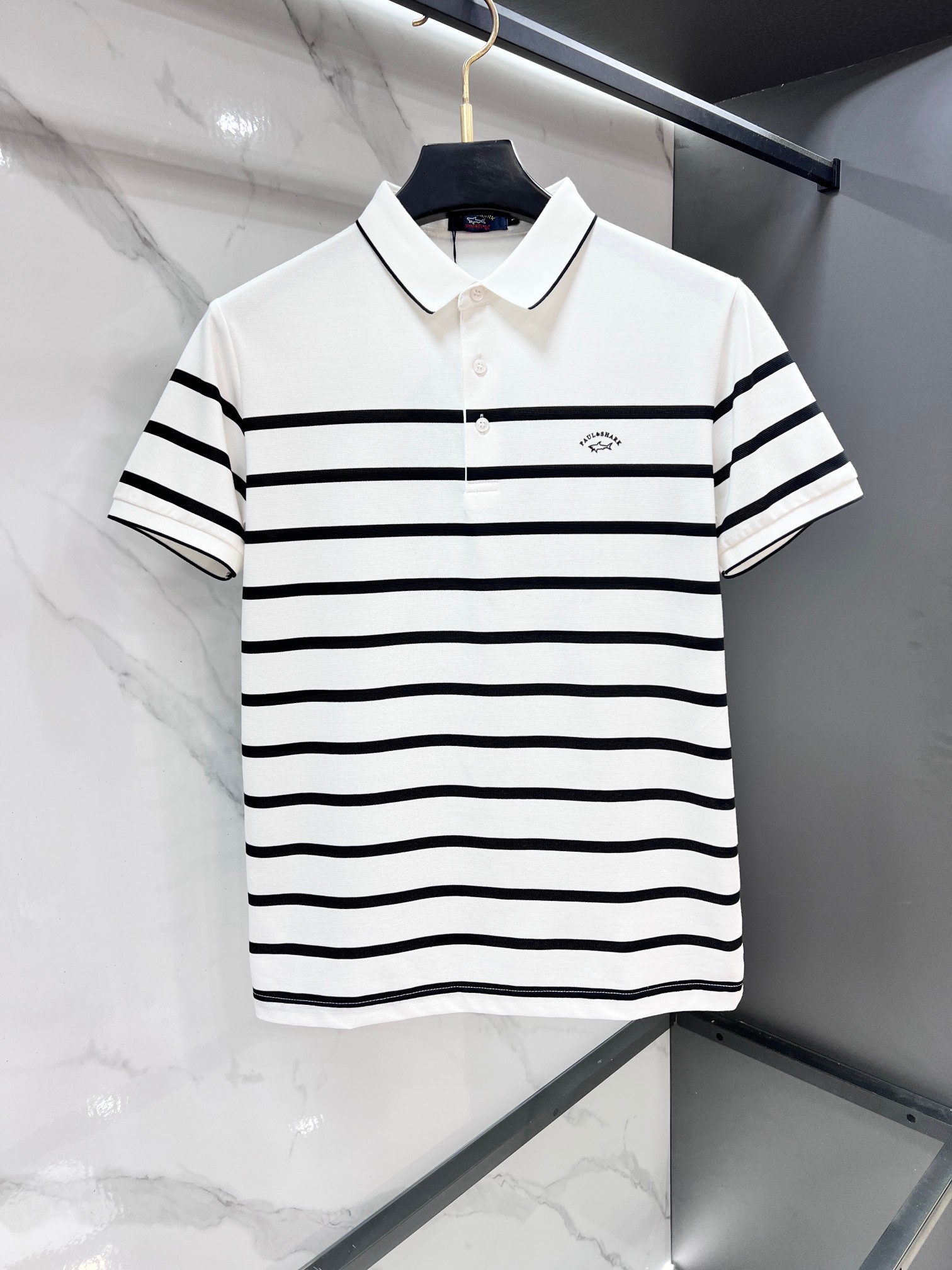 NO:947141,Shark 2026 new shark embroidered letter logo embroidered business casual short-sleeved Polo shirt. This Polo shirt is synonymous with low-key luxury and is specially designed for men who pursue quality. The classic lapel is matched with a two-button placket, and the neat tailoring modifies the body shape and does not choose the figure or the occasion. The black and white double stripe design on the cuffs breaks the monotony and highlights the taste in the details; the embroidered letters on the chest echo the armband badge, quietly conveying the light luxury status.  The fabric is made of high-count piqué cotton, which is breathable and skin-friendly, stiff and not easy to wrinkle. It is refreshing and not sweaty when worn in summer, and can stay flat even if you sit for a long time. Whether it is worn with trousers for commuting in the workplace or jeans for casual weekends, it can easily hold the sense of dignity, clean and neat yet exquisite style, and is a basic style that will never go out of style in the wardrobe.…………………………………………………… SizeM-XXXXL, jeans, T-shirt,19860909鲨鱼 2026新款鲨鱼刺绣字母logo绣花商务休闲短袖Polo衫,这件Polo衫是低调高级感的代名词,专为追求质感的男士打造.经典翻领搭配两粒扣门襟,利落剪裁修饰身形,不挑身材也不挑场合.袖口黑白双条纹设计,打破单调感,细节处彰显品味；胸口刺绣字母与臂章徽章遥相呼应,悄悄传递轻奢身份. 面料选用高支珠地棉,透气亲肤、挺括不易皱,夏天穿着清爽不闷汗,久坐也能保持平整.无论是职场通勤搭配西裤,还是周末休闲配牛仔裤,都能轻松hold住体面感,干净利落又不失精致格调,是衣橱里永不过时的基础款.…………………………………………………… SizeM-XXXXL,,jeans,T-shirt,,Men's clothing
