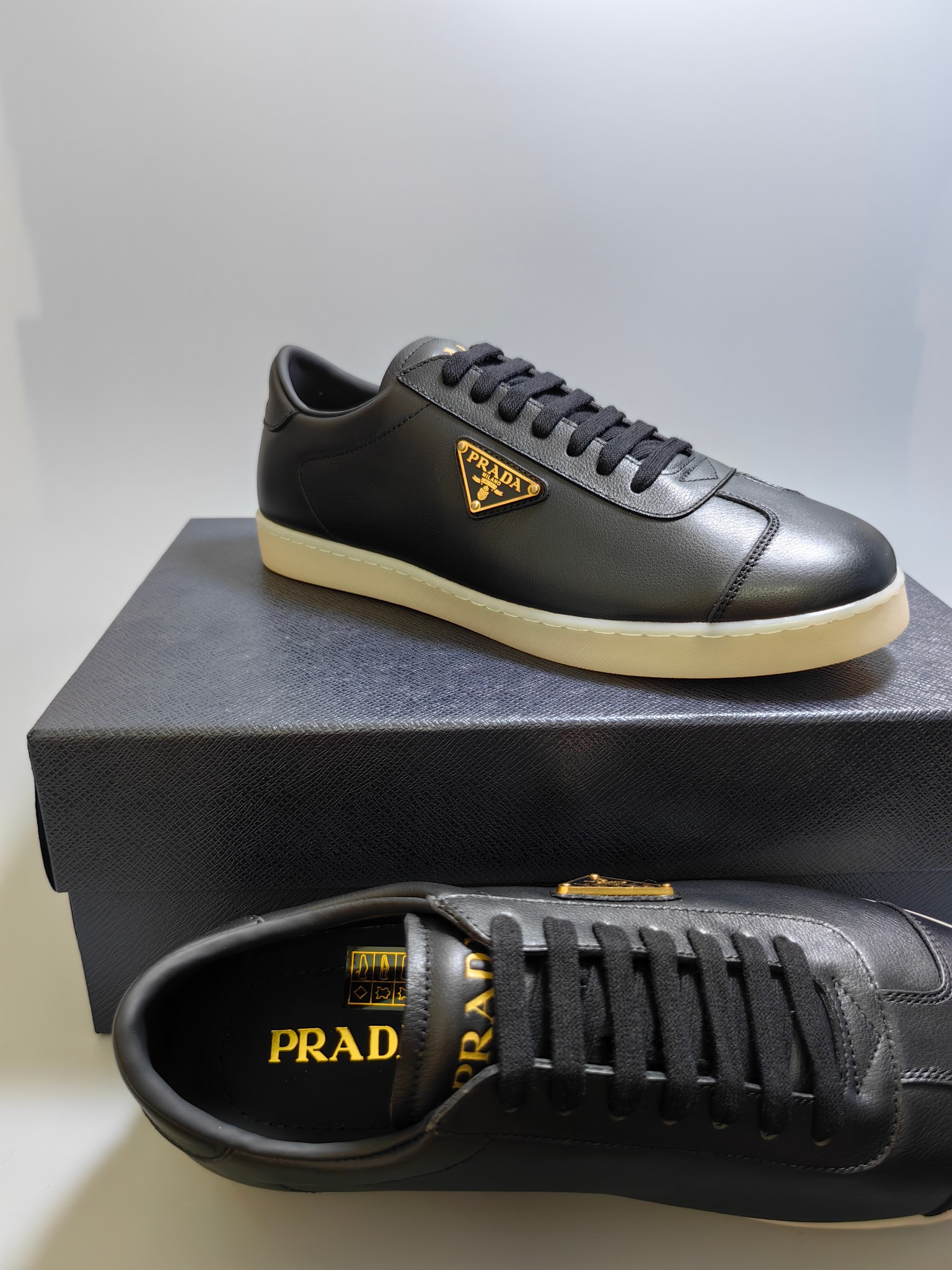 NO:273040,P home luxury products and men's fashionable shoe series, this leather sneaker interprets the Pra* logo from multiple angles, lightly leaps on the tongue, lays along the light rubber sole, and embosses the upper side of the upper, all explaining the brand style. Imported calfskin material, calfskin on the inner layer with calf insoles, classic logo decoration on the side of the shoe, original rubber outsole, anti-slip and wear-resistant, and extremely comfortable classic style!  Size38-45, prada,sneakers,cowhide19860909P 家奢品、男士时尚板鞋系列,这款皮革运动鞋多角度诠释Pra*徽标轻巧跃于鞋舌,沿轻质橡胶鞋底铺陈,化身橡胶三角形点缀鞋面一侧,无不阐释品牌格调.进口小牛皮材质,内里头层小牛皮搭配小牛鞋垫,鞋身侧经典logo装饰,原版橡胶大底,防滑耐磨,舒适度极高的经典款！ Size38-45,,prada,sneakers,cowhide,Men's shoes