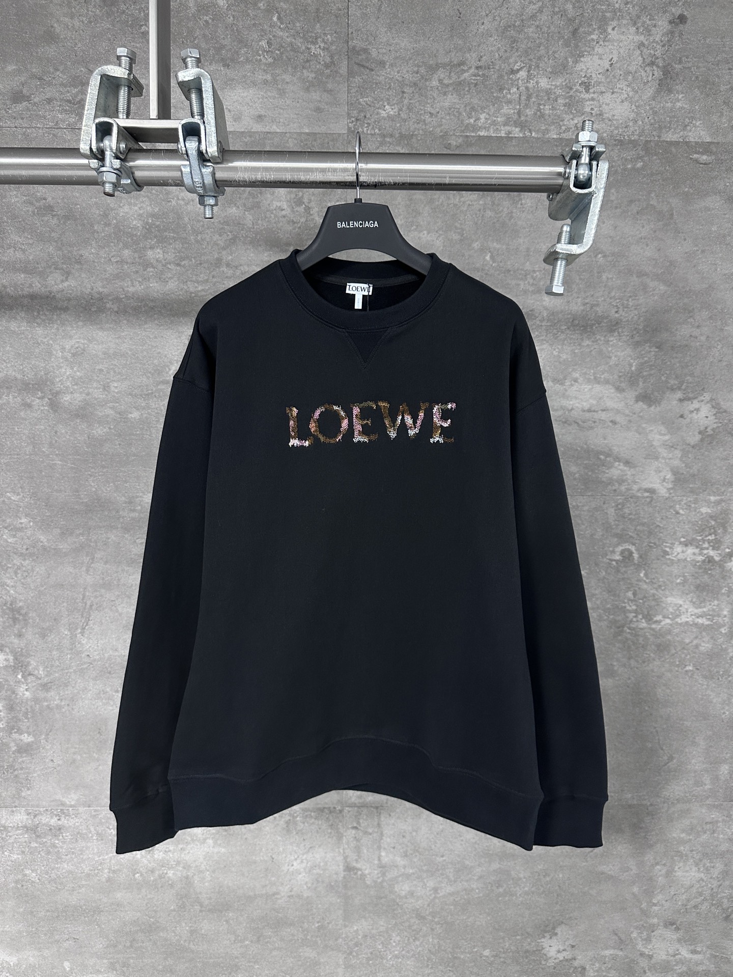 NO:523969,LOEWE/Luo Yiwei 25ss Rainbow Gradient Letter Embroidered Round-neck Sweatshirt  The fabric may feel very soft, the texture is light and highly breathable. Through special spinning technology, the fabric has a unique texture and appearance. The tight structure makes the fabric more wear-resistant and wrinkle-resistant, and can maintain beauty and smoothness for a long time. The front is decorated with blended yarn embroidery and the core material of the multi-color blended yarn embroidery process. It is made of fibers of different colors to form a unique color gradient or mottled effect. The color matching and fabric are carried out according to the pattern design and the color of the blended yarn.  Bureau planning to ensure color matching and transition, as well as uniform and neat needle methods, use appropriate techniques to collect needles to ensure that the thread head is hidden, simple vertical round neck short-sleeved version, develop extremely simple body cut for paper patterns, knitted material has certain extension performance, the upper body will not tightly bind, round neck same-color rib splicing neckline, and strip sticking process of the back neckline effectively prevents the neckline deformation after multiple washes, fit shoulder line, bottom swing and cuff special machine knight car open line edge collection, custom auxiliary materials three standards, custom hardware  Thread Auxiliary Materials Same Model for Men and Women -Color: Black -Size: Xs S M L,,loewe,loewe,hoodie,sweatshirts,T-shirt,alexander wang19860909LOEWE/罗意威 25ss 彩虹渐变字母刺绣圆领卫衣 面料的手感可能非常柔软,质地轻薄并有高度透气性,通过特纺工艺,面料具有独特的纹理和外观,紧密的结构使得面料更加耐磨、抗皱,能够保持较长时间的美观和平整,正面饰有混纺纱线刺绣,多色混纺纱线刺绣工艺的核心材料,由多种不同颜色的纤维混纺而成,形成独特的色彩渐变或斑驳效果,根据图案设计和混纺纱线的颜色,进行色彩搭配和布局规划,确保色彩搭配和过渡,以及针法的均匀和整洁,用适当的技法进行收针,确保线头被隐藏处理,简约垂直圆领短袖版型,对版纸样开发极简直身剪裁,针织材质具有一定延展性能,上身不会紧紧束身,圆领同色罗纹拼接领口,后领口内贴条工艺,有效防止多次穿洗后领口变形,合身肩线,底摆与袖口专机坎车明线收边,定制辅料三标,定制五金 螺纹 辅料 对版对位 男女同款 -Color: 黑色 -Size: Xs S M L,,loewe,loewe,hoodie,sweatshirts,T-shirt,alexander wang,Men's clothing