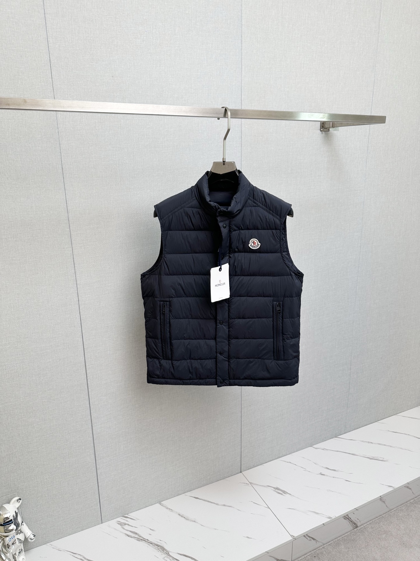 NO:615192,MOC25FW new autumn and winter navy blue nylon stand collar down vest, classic felt badge lightweight down jacket vest for men and women!  Trading company channels are rare and available on the official website simultaneously!  Farmon's new lightweight down vest, with its excellent fabrics, high-quality filling, exquisite decoration, unique design and fitted version, has become the perfect combination of fashion and warmth!  Wearing it can not only protect you from the cold, but also show your unique taste and fashion attitude!  This vest is made of custom-made densely woven nylon fabric. Its densely woven structure makes the fabric tight and strong, which can effectively block the intrusion of cold air from the outside and build a solid line of defense for the body to keep warm!  At the same time, it has good breathability and will not make the body feel stuffy or uncomfortable during wearing. It is like installing an intelligent temperature control system on the body to always maintain a comfortable state!  The interior is filled with national standard 90 white duck down, which has strong thermal insulation properties and tightly locks in body heat, allowing you to feel as warm as spring in cold weather!  And paired with exquisite quilting technology, these white duck down quilts are cleverly fixed in corresponding positions and distributed very evenly, without being too thick or too thin locally. The overall upper body effect is extremely light, as if the body is covered with a layer of soft clouds, without any sense of burden, but extremely warm!  The iconic felt badge embroidery on the chest is made of exquisite felt material. It has been carefully hand-embroidered by craftsmen, and every detail is handled just right!  This badge is not just a simple decoration, but also a status symbol. It represents unique taste and the pursuit of quality life!  The placket adopts a buttoned zipper opening and closing design. This unique design perfectly combines the classic buttoning with the convenience of a zipper!  The hardware has excellent texture, and every part has been carefully polished and exudes the unique luster of metal, demonstrating high-quality craftsmanship!  The fashionable small stand-up collar design is simple and capable. It can fit the neck well and keep warm without looking too bulky!  The fitting style is the finishing touch of this vest. It can perfectly fit the body curve and show your graceful figure. Dark blue size 1-5. Size 1 shoulder width 43cm - bust 108cm - length 62cm. Size 2 shoulder width 44cm - bust 112cm - length 63cm. Size 3 shoulder width 45cm - bust 116cm - length 64cm.  Size 4 has shoulder width 46cm - bust 120cm - dress length 66cm. Size 5 has shoulder width 47cm - bust 124cm - dress length 68cm. Size recommendation (standard version). Height 174-140 catties. Try on size 2 which is suitable!  Boys weighing less than 130 kilograms choose size 1, 130-142 kilograms choose size 2, 142-154 kilograms choose size 3, 154-168 kilograms choose size 4, 168-183 kilograms choose size 5!  All girls can choose size 1!  ,,jackets & coats,down jacket,alexander wang19860909MOC25FW秋冬新款藏蓝色尼龙立领羽绒马甲,男女同款经典毛毡徽章轻薄款羽绒服马甲外套！贸易公司渠道稀出,同步官网发售！法蒙家全新轻薄款羽绒马甲,以其卓越的面料、优质的填充、精致的装饰、独特的设计和合身的版型,成为了时尚与温暖的完美结合体！穿上它你不仅能抵御寒冷,更能展现出自己的独特品味和时尚态度！ 这款马甲采用客供定制密织尼龙面料,其密织结构使得面料紧密而结实,能够有效阻挡外界冷空气的侵入,为身体构筑起一道坚实的保暖防线！同时它又具有良好的透气性,不会让身体在穿着过程中感到闷热和不适,就像给身体安装了一个智能的温控系统,始终保持舒适的状态！内里采用国标90白鸭绒进行填充,具有极强的保暖性能,紧紧锁住身体的热量,让你在寒冷的天气里也能感受到如春日般的温暖！并且搭配上精湛的绗缝工艺,这些白鸭绒被巧妙地固定在相应的位置,分布得十分均匀,不会出现局部过厚或过薄的情况,整体上身效果轻盈无比,仿佛身上披着一层轻柔的云朵,毫无负担感,却又温暖至极！ 胸前标志性毛毡徽章刺绣,采用了精致的毛毡材质,经过工匠们细致的手工刺绣,每一个细节都处理得恰到好处！这枚徽章不仅仅是一个简单的装饰,更是一种身份的象征,它代表着独特的品味和对品质生活的追求！门襟采用了排扣拉链开合设计,这种独特的设计将排扣的经典与拉链的便捷完美结合！五金质感极佳,每一个零件都经过精心打磨,散发着金属特有的光泽,彰显出高品质的工艺水准！时尚的小立领设计,造型简洁而干练,既能够很好地贴合颈部,起到保暖的作用,又不会显得过于臃肿！合身的版型更是这款马甲的点睛之笔,它能够完美地贴合身体曲线,展现出你的优美身姿.深蓝色 尺码1-5 1码肩宽43cm-胸围108cm-衣长62cm 2码肩宽44cm-胸围112cm-衣长63cm 3码肩宽45cm-胸围116cm-衣长64cm 4码肩宽46cm-胸围120cm-衣长66cm 5码肩宽47cm-胸围124cm-衣长68cm 尺码推荐（标准版型） 身高174-140斤,试穿2码合适！ 男生体重130斤以内选择1码,130-142斤选择2码,142-154斤选择3码,154-168斤选择4码,168-183斤选择5码！ 女生全部选择1码即可！,,jackets & coats,down jacket,alexander wang,Men's clothing