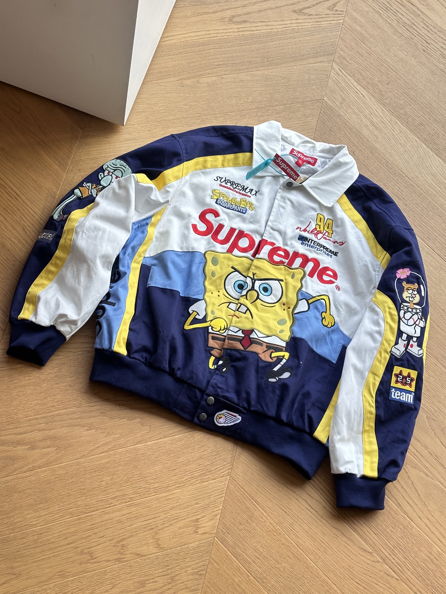 供💰400 🇷🇺Supreme x SPONGEBOB SQUAREPANTS海绵宝宝 x JEFF HAMILTON 联名款 SS25 WEEK11卡通印花图案刺绣徽标赛车美式潮流夹克🇷🇺男女同款

黑色 白色
S~xl 

🌘顶级版本，原版开发，进口百灵达机器重工几十万针刺绣，海绵宝宝卡通图案栩栩如生，超多撞色裁片一比一对版对位，这就是天花板.

尺码表：175 120穿s合适
S:胸围136 衣长70 肩宽59
M:胸围140 衣长72 肩宽60.2
L:胸围144 衣长74 肩宽61.4
xl:胸围148 衣长76 肩宽62.6