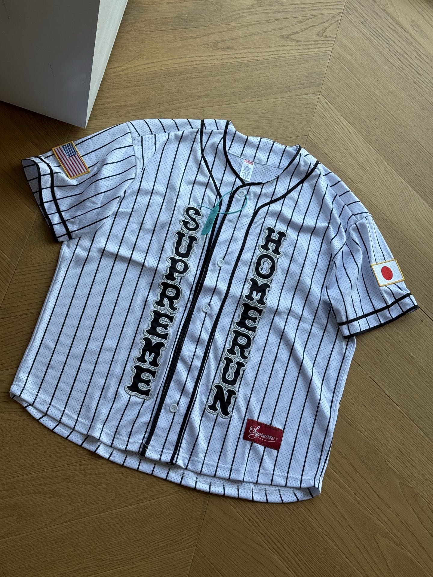 供💰185 🇷🇺Supreme x Homerun 联名款 SS25 WEEK12 Baseball Jersey 标签logo网眼舒适短袖棒球衫🇷🇺男女同款

黑色 白色 绿色
S~xl 

🌘日本职棒Homerun的联名系列，黑绿采用撞色设计，白色则是棒球经典的条纹元素。开衫左右分别有supreme和homerun的字体logo，袖标也是日美的图案，而背部则是newyork和tokyo两大时尚之都，可以说是联名细节满满的一件单品。

尺码：175 120穿s合适
        胸围   衣长   肩宽   袖长
S：   124	  72     54	   24.5	
M：  128	  74     56	    25	
L：   132	  76     57	    25.5
XL： 136      78     58	    26