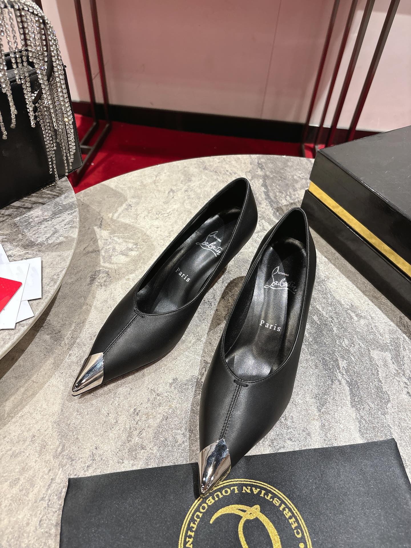 Title: Louboutin One-Shoe Description: High heel Louboutin shoe with red soles, silver hardware, black leather, and innovative coating for durability. Sizes 35-43
