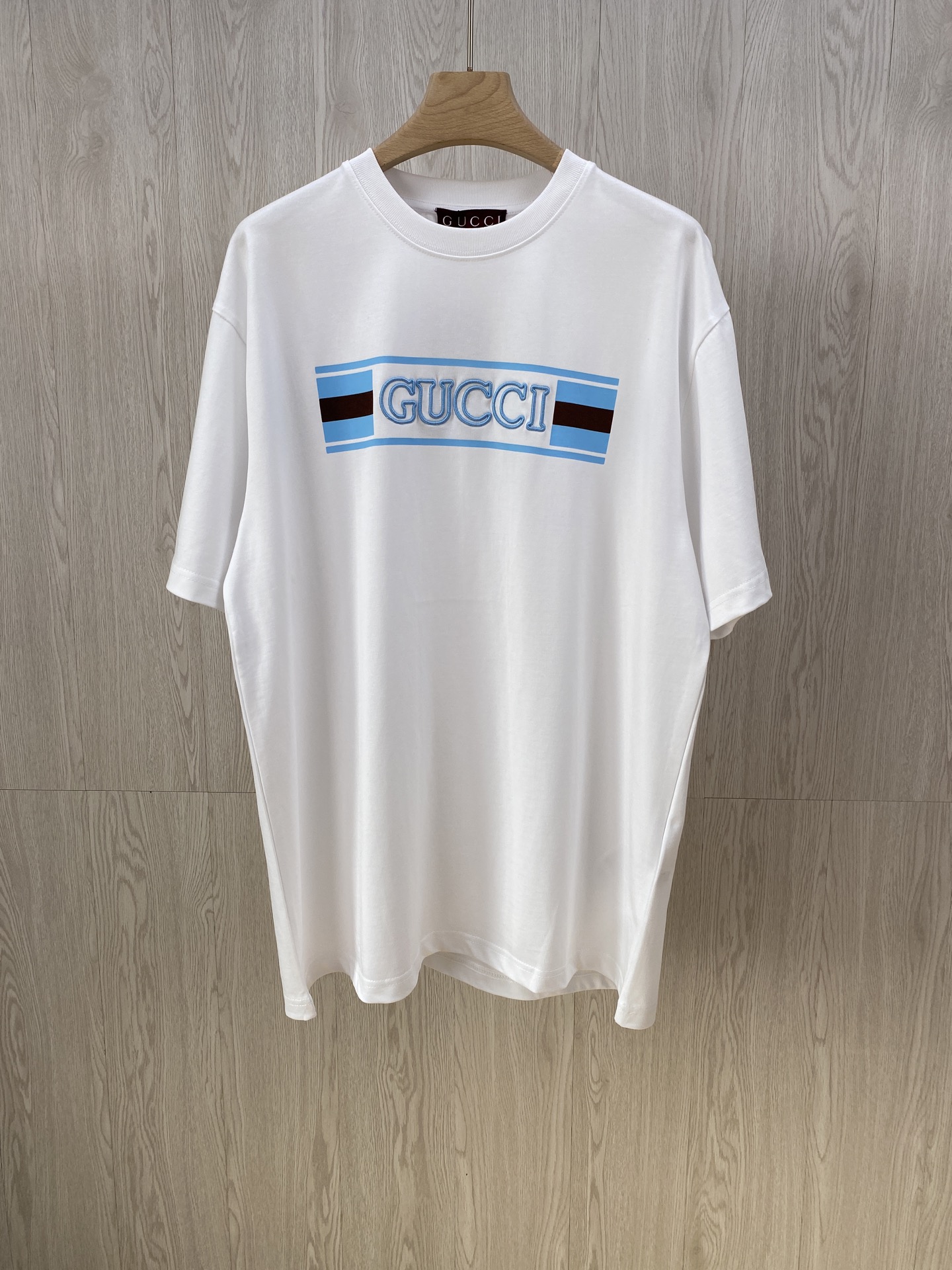 NO:121418,GU flag print and embroidered round neck short sleeves. The colors are sold in white and blue. Fine velvet knitted cotton fabric, GU webbing flag printing, three-dimensional embroidery process, round neck short sleeves, standard version, full set of auxiliary materials. Pure cotton knitted plain fabric is made of 15S fine cotton plain fabric, 230g; matched with 32S double yarn thread, 300g. Plain weave fabric made of cotton fiber treated with combed process. Compared with ordinary cotton fabrics, its fiber arrangement is more neat and dense, so it has better texture and luster. 15S fine cotton plain fabric is a high-quality cotton fabric, which has the characteristics of softness, comfort, good breathability, and good durability. # Silicone oil high-density elastic paste printing  Silicone oil high-density elastic glue printing is a special printing process with good elasticity and adhesion. The scratch resistance of high-density elastic glue is 5 times that of ordinary glue, which can ensure that the printing pattern is not easily scratched during wear and use. Good washing resistance, even after multiple washings, the printing pattern can still remain clear and bright. # Three-dimensional needle embroidery process The main body of the letter adopts precision needle embroidery process; the embroidery is very fine and dense, the pattern is clear and the line feel is strong. The line is combined with the encryption process, and the embroidery body has a subtle matte visual texture; the embroidery effect is three-dimensional and full. The flat embroidery thread is uniquely designed, and the embroidery is very fine and dense; the overall stitching is fine and the texture is consistent, which adds a sense of layering to the simple design. # Round neck straight cylinder version  Loose clothes cut, no body typing or body shape. Round neck collar, shoulder line drops shoulder width, no shoulder width, elastic inserts are embedded inside to prevent multiple wear and washing clothes. The cuffs and bottom edges of the hem are used to fix the double-bright edges. Number of codes XS S M L.,,T-shirt,alexander wang19860909GU旗帜印绣圆领短袖.发售色系白色、蓝色 细绒针织棉面料、GU织带旗帜印花、立体刺绣工艺、圆领短袖、标准版型、全套辅料配备 纯棉质针织平纹面料 采用15S精棉平纹面料,230g；搭配32S双纱螺纹,300g.采用精梳工艺处理的棉纤维制成的平纹织物,相对于普通棉布而言,它的纤维排列更加整齐、密度更高,因此具有更好的质地和光泽.15S精棉平纹面料是一种高品质的棉质面料,具有柔软舒适、透气性好、耐用性好等特点. # 硅油高密度弹力胶浆印花 硅油高密度弹力胶浆印花是一种特殊的印花工艺,具有良好的弹性和附着力,高密度弹力胶浆的抗刮性能是普通胶浆的5倍,能够确保印花图案在穿着和使用过程中不易被刮损.良好的耐洗水性,即使在多次洗涤后,印花图案依然能够保持清晰和鲜艳. # 立体挨针刺绣工艺 字母主体采用精密挨针绣工艺；刺绣非常精细针法绵密,图案清晰且线条感和立体感强.亚麻材质绣线结合加密处理,绣体具有微妙的哑光视觉质感；刺绣效果立体饱满.平绣的挨针走线独特设计,刺绣非常精细针法绵密；整体针脚细密,精细度质感一致,为简约设计增添了层次感. # 圆领直筒版型 宽松衣型裁剪,不束身不限制身型.圆领领口,肩线落肩,不限制肩宽,内部做缝处以弹力嵌条的嵌入防止多次穿洗后衣身走行.袖口、下摆底边采用的分别专机辑双明线收边固定. 码数 XS S M L.,,T-shirt,alexander wang,Men's clothing