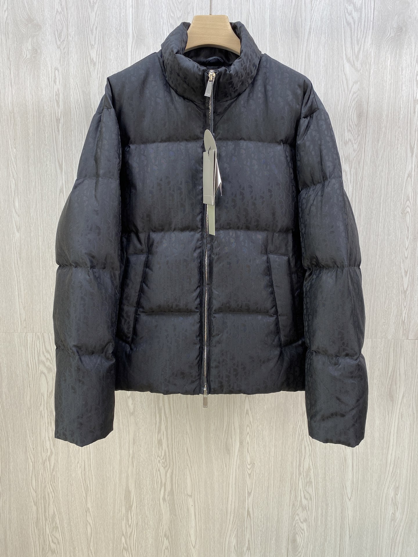 NO:573217,CD Xiaodi's classic Dior all-print jacquard down jacket.  DIOR stand-up collar bread down jacket. The fabric uses scientific jacquard technology and laser jacquard technology is applied to the fabric to make the whole garment more concave and convex and have a stronger three-dimensional effect. This technology not only improves the visual effect of the fabric, but also enhances the durability and comfort of the fabric. The design of the stand-up collar not only improves the thermal performance, but also adds a sense of sophistication and neatness to it. This collar type can well modify the neck line  , showing the elegance of the wearer. The internal lidless secret pockets are cleverly integrated into the design. Not only are they practical and can store some small items, but they also add a low-key and exquisite feeling to the overall shape through concealed design. Oblique printing is applied to the fabric through precision printing technology and perfectly blends with the fabric, presenting a low-key and luxurious visual effect.   The down filling uses high-quality 90 white duck down as the filling. It has been strictly processed and screened to ensure the fluffiness and warmth of the down. The down is evenly filled into the inner bladder of the vest and fixed by sewing and gluing. Size 46 48 50 52.,, dior, dior, down jacket, alexander wang19860909CD小迪经典款 迪奥满印提花羽绒服. DIOR立领面包羽绒服.面料采用科技提花技术在面料上应用激光提花技术,使整件衣服凹凸有致,立体感更强.这种技术不仅提升了面料的视觉效果,还增强了面料的耐用性和舒适度.立领的设计不仅提升了保暖性能,还为其增添了一份干练与利落.这种领型能够很好地修饰颈部线条,展现出穿着者的优雅气质.内部的无盖暗袋,都巧妙地融入了设计之中.不仅具有实用性,能够放置一些小物品,还通过隐蔽的设计方式,为整体造型增添了一抹低调而精致的感觉Oblique印花通过精密的印刷技术应用于面料上,与面料完美融合,呈现出低调而奢华的视觉效果. 羽绒填充选用高品质的90白鸭绒作为填充物,经过严格的处理和筛选,确保羽绒的蓬松度和保暖性.将羽绒均匀地填充到马甲的内胆中,并通过缝制压胶等方式固定. 尺码46 48 50 52.,,dior,dior,down jacket,alexander wang,Men's clothing