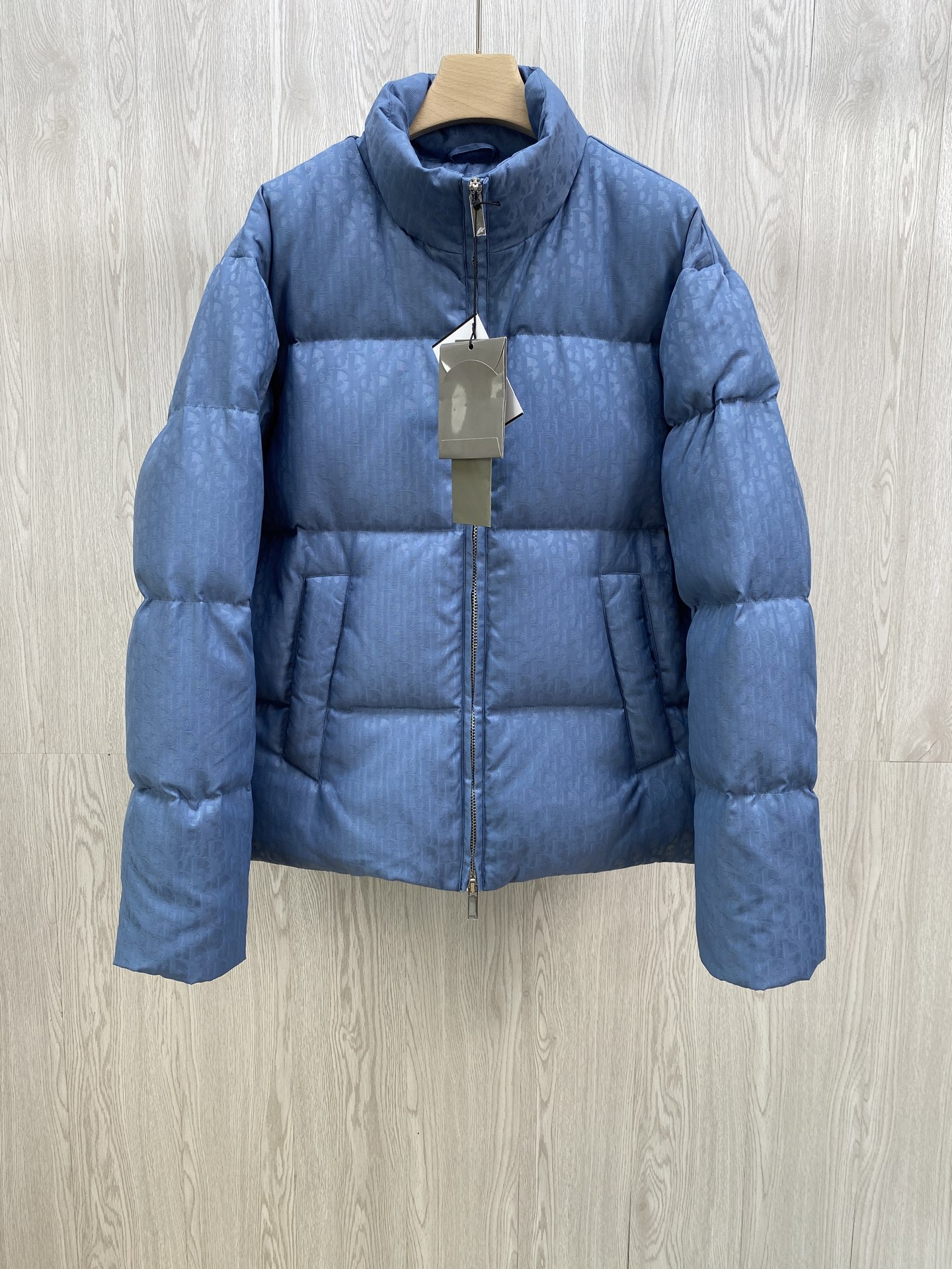 NO:573223,CD Xiaodi's classic Dior all-print jacquard down jacket.  DIOR stand-up collar bread down jacket. The fabric uses scientific jacquard technology and laser jacquard technology is applied to the fabric to make the whole garment more concave and convex and have a stronger three-dimensional effect. This technology not only improves the visual effect of the fabric, but also enhances the durability and comfort of the fabric. The design of the stand-up collar not only improves the thermal performance, but also adds a sense of sophistication and neatness to it. This collar type can well modify the neck line  , showing the elegance of the wearer. The internal lidless secret pockets are cleverly integrated into the design. Not only are they practical and can store some small items, but they also add a low-key and exquisite feeling to the overall shape through concealed design. Oblique printing is applied to the fabric through precision printing technology and perfectly blends with the fabric, presenting a low-key and luxurious visual effect.   The down filling uses high-quality 90 white duck down as the filling. It has been strictly processed and screened to ensure the fluffiness and warmth of the down. The down is evenly filled into the inner bladder of the vest and fixed by sewing and gluing. Size 46 48 50 52.,, dior, dior, down jacket, alexander wang19860909CD小迪经典款 迪奥满印提花羽绒服. DIOR立领面包羽绒服.面料采用科技提花技术在面料上应用激光提花技术,使整件衣服凹凸有致,立体感更强.这种技术不仅提升了面料的视觉效果,还增强了面料的耐用性和舒适度.立领的设计不仅提升了保暖性能,还为其增添了一份干练与利落.这种领型能够很好地修饰颈部线条,展现出穿着者的优雅气质.内部的无盖暗袋,都巧妙地融入了设计之中.不仅具有实用性,能够放置一些小物品,还通过隐蔽的设计方式,为整体造型增添了一抹低调而精致的感觉Oblique印花通过精密的印刷技术应用于面料上,与面料完美融合,呈现出低调而奢华的视觉效果. 羽绒填充选用高品质的90白鸭绒作为填充物,经过严格的处理和筛选,确保羽绒的蓬松度和保暖性.将羽绒均匀地填充到马甲的内胆中,并通过缝制压胶等方式固定. 尺码46 48 50 52.,,dior,dior,down jacket,alexander wang,Men's clothing