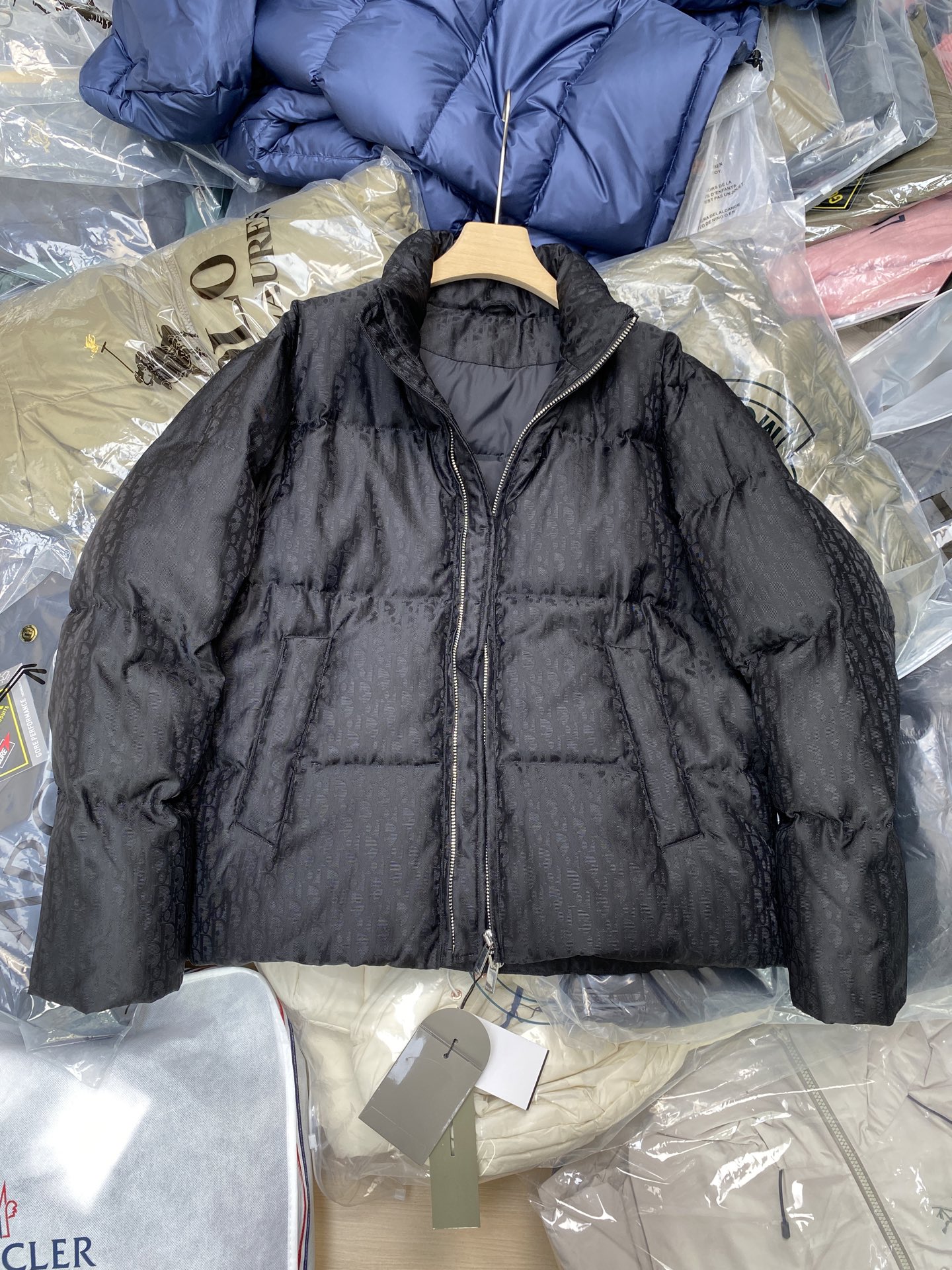 NO:573226,CD Xiaodi's classic Dior all-print jacquard down jacket.  DIOR stand-up collar bread down jacket. The fabric uses scientific jacquard technology and laser jacquard technology is applied to the fabric to make the whole garment more concave and convex and have a stronger three-dimensional effect. This technology not only improves the visual effect of the fabric, but also enhances the durability and comfort of the fabric. The design of the stand-up collar not only improves the thermal performance, but also adds a sense of sophistication and neatness to it. This collar type can well modify the neck line  , showing the elegance of the wearer. The internal lidless secret pockets are cleverly integrated into the design. Not only are they practical and can store some small items, but they also add a low-key and exquisite feeling to the overall shape through concealed design. Oblique printing is applied to the fabric through precision printing technology and perfectly blends with the fabric, presenting a low-key and luxurious visual effect.   The down filling uses high-quality 90 white duck down as the filling. It has been strictly processed and screened to ensure the fluffiness and warmth of the down. The down is evenly filled into the inner bladder of the vest and fixed by sewing and gluing. Size 46 48 50 52,, dior, dior, down jacket, alexander wang19860909CD小迪经典款 迪奥满印提花羽绒服. DIOR立领面包羽绒服.面料采用科技提花技术在面料上应用激光提花技术,使整件衣服凹凸有致,立体感更强.这种技术不仅提升了面料的视觉效果,还增强了面料的耐用性和舒适度.立领的设计不仅提升了保暖性能,还为其增添了一份干练与利落.这种领型能够很好地修饰颈部线条,展现出穿着者的优雅气质.内部的无盖暗袋,都巧妙地融入了设计之中.不仅具有实用性,能够放置一些小物品,还通过隐蔽的设计方式,为整体造型增添了一抹低调而精致的感觉Oblique印花通过精密的印刷技术应用于面料上,与面料完美融合,呈现出低调而奢华的视觉效果. 羽绒填充选用高品质的90白鸭绒作为填充物,经过严格的处理和筛选,确保羽绒的蓬松度和保暖性.将羽绒均匀地填充到马甲的内胆中,并通过缝制压胶等方式固定. 尺码46 48 50 52,,dior,dior,down jacket,alexander wang,Men's clothing