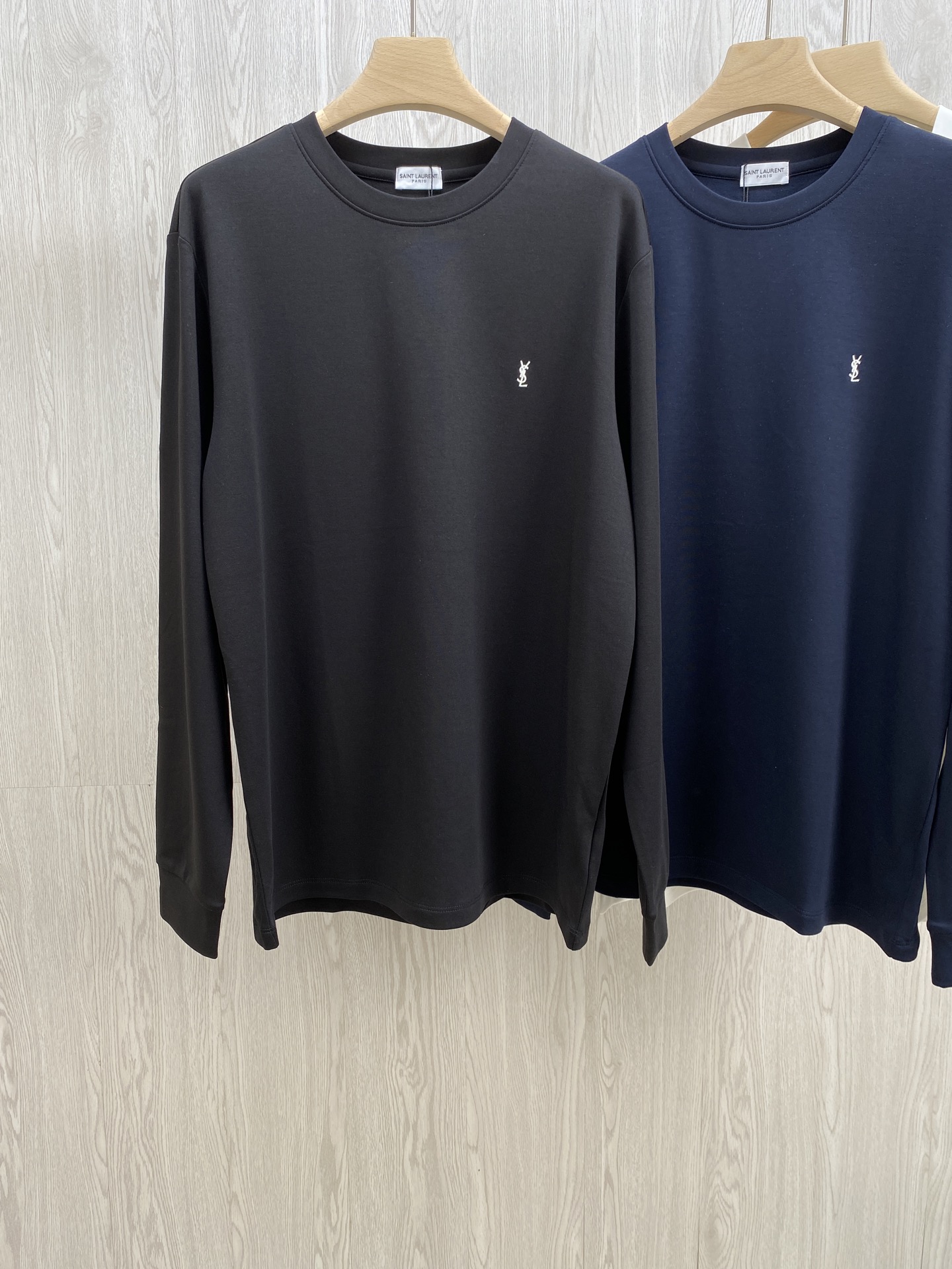 NO:573241,The combination of YSL luxury-grade textured long-sleeved T-shirt Tencel Modal and wool. The silky luxury of Tencel Modal meets the warmth, softness and skin-friendliness of wool. A long-sleeved T-shirt that redefines 'luxury everyday' was born.  The outer layer is made of Tencel modal blended fabric, which feels as smooth as satin at the touch of your fingertips. It has a low-key and high-end luxury luster when you walk, making the simple version more exquisite. The inner woolen fleece wraps the body like a gentle warmth, and is very close to the skin. It is warm and has no sense of restraint when wearing it in autumn and winter.   The iconic brand YSL embroidery is embellished on the chest, and the details are full of style. Whether worn alone to create a light luxury style, or layered to create a layered look, it can be easily held. From fabrics to craftsmanship, everything tells the definition of 'extreme quality', allowing you to touch the luxury temperature at any time in your daily wear. Same style for men and women, black, blue and white; XS-L size; 1-3CM error when measuring flat.  XS code: shoulder width 45 bust 102 dress length 68 sleeves 62 S code: shoulder width 46 bust 106 dress length 70 sleeves 63 M code: shoulder width 47 girth 110 dress length 72 sleeves 64 L code: shoulder width 48 bust 114 dress length 74 sleeves 65 Girls choose XS code; boys under 135 pounds choose XS code; 135-150 pounds choose S code;   If you are 150-165 pounds, choose size M; if you are 165-185 pounds, choose size L.,,saint laurent,tees,t-shirt,silk fabric,alexander wang19860909YSL奢品级质感长袖T恤天丝莫代尔与羊毛绒的结合 当天丝莫代尔的丝滑奢光邂逅羊毛绒的暖柔亲肤,一件重新定义“奢华日常”的长袖T恤就此诞生. 外层采用天丝莫代尔混纺面料,指尖轻触便是绸缎般的顺滑质感,行走间泛着低调又高级的奢品光泽,将简约版型衬得愈发精致；内里羊毛绒加持,像把温柔暖意裹在身上,亲肤度拉满,秋冬穿着既保暖又毫无束缚感. 标志性的品牌YSL刺绣点缀胸前,细节处尽显格调.无论是单穿塑造轻奢风,还是叠穿打造层次感,它都能轻松hold住.从面料到工艺,每一处都在诉说着“极致品质”的定义,让你在日常穿搭中,随时能触摸到奢华的温度. 男女同款,黑色 蓝色 白色 ；XS-L码； 平铺测量1-3CM误差 XS码:肩宽45胸围102衣长68袖子62 S码:肩宽46胸围106衣长70袖子63 M码:肩宽47围110衣长72袖子64 L码:肩宽48胸围114衣长74袖子65 女生选择XS码； 男生 135斤以下选择XS码；135-150斤选择S码； 150-165斤选择M码；165-185斤选择L码.,,saint laurent,tees，t-shirt,silk fabric,alexander wang,Men's clothing