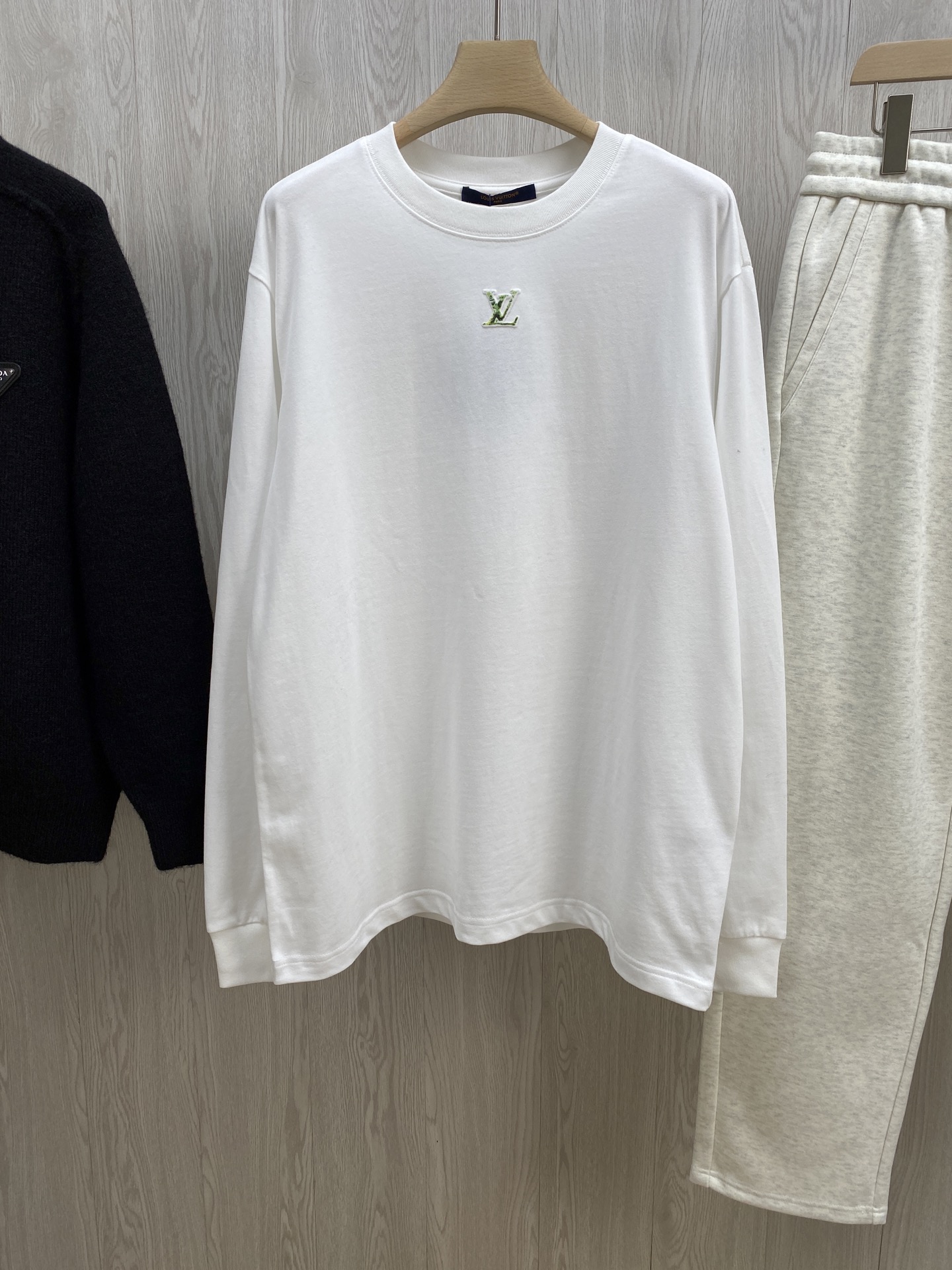 NO:683037,V Snow Mountain Long Sleeve T-shirt｜A double feast of style and texture  Classic Monogram meets the artistic texture of snowy mountains. It is made of pure white high-weight cotton as the base. The ratio of 99% cotton mixed with 1% polyester fiber gives the fabric a soft, skin-friendly feel and a stiffness that is not easily deformed. The exquisite V embroidery logo on the chest is low-key and luxurious, and the snowy mountain embossed pattern on the back is combined with the ink-dyed yellow, green and black texture. The three-dimensional relief texture is full, as if the majesty of the Alps is worn on the body.  The classic woven label on the neckline and the leather LOGO label on the back, every detail interprets V's craftsmanship. The loose fit is not flattering on the body shape. Whether worn alone to create a casual street style, or worn inside to create a layered look, you can easily create a high-end atmosphere. Same style for men and women, white, XS-L size. 1-3CM error when measuring flat. XS size: shoulder width 49, chest 116, length 73, sleeves 49  S code: Shoulder width 50 Bust 120 Clothes length 75 Sleeves 50 M code: Shoulder width 51 Bust 124 Clothes length 77 Sleeves 51 L code: Shoulder width 52 Bust 128 Clothes length 79 Sleeves 52 Girls choose XS code; boys below 135 pounds choose XS code; 135-155 pounds choose S code;  If you weigh 155-175 pounds, choose size M; if you weigh 175-200 pounds, choose size L.,,tees,t-shirt,19860909V雪山长袖T恤｜格调与质感的双重盛宴 经典Monogram邂逅雪山艺术肌理,以纯白高克重棉料打底,99棉混1聚酯纤维的配比,让面料兼具软糯亲肤的触感与不易变形的挺括度；胸前精致的V刺绣小标低调藏奢,背后的雪山压印图案融合水墨晕染的黄绿黑纹理,立体浮雕质感拉满,仿佛将阿尔卑斯山的壮阔穿在身上. 领口的经典织标、后背的皮质LOGO贴标,每一处细节都诠释着V的匠心工艺.宽松的版型不挑身形,无论是单穿打造随性街头风,还是内搭叠穿塑造层次感,都能轻松拿捏高级氛围感. 男女同款,白色,XS-L码. 平铺测量1-3CM误差 XS码:肩宽49胸围116衣长73袖子49 S码:肩宽50胸围120衣长75袖子50 M码:肩宽51胸围124衣长77袖子51 L码:肩宽52胸围128衣长79袖子52 女生选择XS码； 男生 135斤以下选择XS码；135-155斤选择S码； 155-175斤选择M码；175-200斤选择L码.,,tees，t-shirt,,Men's clothing