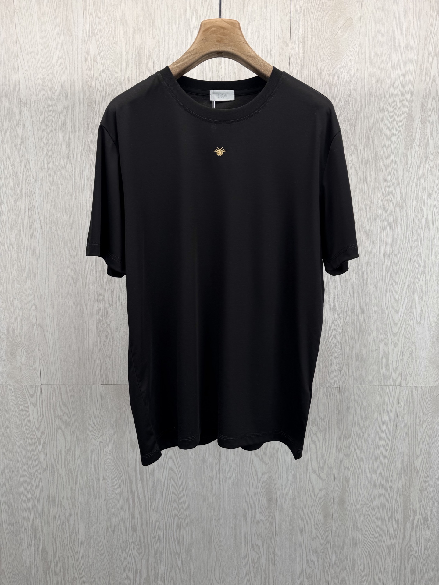 NO:779784,.CD Xiaodi’s classic golden bee embroidery cool short-sleeved T-shirt. Bee’s iconic golden bee embroidery is a low-key way to highlight the brand’s genes. The exquisite three-dimensional golden bee embroidery on the left chest has fine and full stitches, and the gold foil textured embroidery thread shines smartly under the light.  It adopts a golden ratio of 43.8 modal + 37.6 cotton + 18.6 polyester fiber. It is treated with high-end liquid nitrogen technology. The fabric is as silky as the second layer of skin. It is cold to the touch on the upper body. It is breathable and does not make you sweat. It can keep you dry even at high temperatures of 35°C. The high-count cotton fiber enhances the stiffness, and the polyester fiber enhances wrinkle resistance. It does not collapse after long-term wear, is not easy to pill, and has a full drape. It is perfect for spring and summer wear.  Classic high-end black color, calm and elegant, showing whiteness without being picky, easy to control various styles. Same style for men and women, black, XS-XL size; DI classic golden bee embroidery cool T-shirt. 1-3CM error in flat measurement  M code: Shoulder width 48 Bust length 73 Sleeve length 23.5 L code: Shoulder width 50 Bust length 75 Sleeve length 24  -Choose XL size., Dior-clothing, dior, T-shirt, tees, t-shirt, gold,19860909.CD小迪经典金蜜蜂刺绣凉感短袖T恤 蜜蜂标志性金蜜蜂刺绣,低调彰显品牌基因.左胸精致立体的金色蜜蜂刺绣,针脚细密饱满,金箔质感的绣线在光线下灵动闪耀,于极简衣身之上,以细节诠释法式奢雅,不张扬却自带高级辨识度,轻松提升穿搭格调. 液氮工艺+高支莫代尔棉,凉感天花板 采用43.8莫代尔+37.6棉+18.6聚酯纤维黄金配比,经高端液氮工艺处理,面料丝滑如第二层肌肤,上身即触冰凉,透气不闷汗,35℃高温也能保持体感干爽；高支棉纤维提升挺括度,聚酯纤维增强抗皱性,久穿不塌、不易起球,垂坠感拉满,完美适配春夏穿搭. 经典高级黑配色,沉稳大气,显白不挑皮,轻松驾驭各种风格. 男女同款,黑色,XS-XL码； DI经典金蜜蜂刺绣凉感T恤 平铺测量1-3CM误差 XS码:肩宽46胸围106衣长69袖长22.5 S码:肩宽47胸围110衣长71袖长23 M码:肩宽48胸围114衣长73袖长23.5 L码:肩宽50胸围118衣长75袖长24 XL码:肩宽52胸围122衣长77袖长24.5 尺码推荐 135斤以下选择XS码；135-150斤选择S码； 150-165斤选择M码；165-斤选择L码； -斤选择XL码.,迪奥-服装,dior,T-shirt,tees，t-shirt,gold,,Women's clothing
