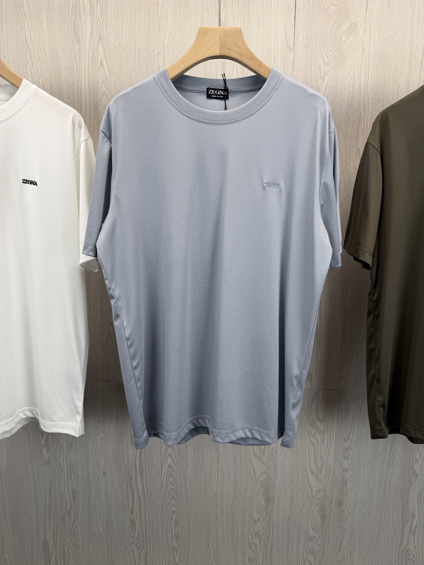 NO:779772,.ZE high-count modal true liquid ammonia short-sleeved T-shirt, a comfortable luxury product for high-end men in summer~ Ace fabric, luxurious silky smoothness  It adopts a golden ratio of 43.8 modal + 37.6 cotton + 18.6 polyester fiber, and is deeply processed by the true liquid ammonia process. The fabric has a silky feel like ice silk, and a full drape feeling. Modal's breathability and skin-friendly + cotton's softness and toughness + polyester fiber's anti-wrinkle and style, the upper body is cool and breathable, and it will not be sweaty or sticky when worn for a long time. It is perfect for hot weather in spring and summer. It is a true 'walking air-conditioned shirt'.  The high-count dense weaving process creates a delicate texture, soft and waxy to the touch, and is wrinkle-resistant. It remains as smooth as new after machine washing, so there is no need to worry about taking care of it. The Z letter embroidery on the chest is of the same color, and the stitching is fine and three-dimensional, low-key to highlight the brand identity, unobtrusive but full of high-end. The classic round neck silhouette and simple solid color design can be easily controlled whether worn alone to create a business casual style, or layered with a suit or jacket to create a layered look. It is suitable for all scenarios of commuting, leisure, and travel.  Same style for men and women, gray blue, khaki brown, apricot white, XS-XL sizes; 1-3CM error in flat measurement;  XL code: shoulder width 48, bust 120, length 76, sleeves 26, girls choose XS code; boys under 130 pounds, choose XS code; 130-145 pounds, choose S size; 145-160 pounds, choose M size; 160-175 pounds, choose L size; 175-190 pounds, choose XL size., men's clothing, jackets & coats, T-shirt, tees, t-shirt, business suit, gold,19860909.ZE高支莫代尔真液氨短袖T恤 高阶男士的夏日舒适奢品~ 王牌面料,奢享丝滑 采用43.8莫代尔+37.6棉+18.6聚酯纤维的黄金配比,经真液氨工艺深度处理,面料自带冰丝般的丝滑触感,垂坠感拉满.莫代尔的透气亲肤+棉的柔软韧性+聚酯纤维的抗皱有型,上身凉感透气,久穿不闷汗、不粘身,完美适配春夏高温天气,是真正的“行走的空调衫”. 高支密织工艺打造细腻肌理,触感软糯如云,同时兼具抗皱性,机洗后依旧平整如新,无需费心打理.胸口同色系Z字母刺绣,针脚细密立体,低调彰显品牌身份,不张扬却尽显高级感. 经典圆领廓形,简约纯色设计,无论是单穿打造商务休闲风,还是内搭西装、夹克打造层次感,都能轻松驾驭,通勤、休闲、出行全场景适配. 男女同款,灰蓝色 卡其棕 杏色 白色,XS-XL码； 平铺测量1-3CM误差 XS码:肩宽44胸围104衣长68袖子22 S码:肩宽45胸围108衣长70袖子23 M码:肩宽46胸围112衣长72袖子24 L码:肩宽47胸围116衣长74袖子25 XL码:肩宽48胸围120衣长76袖子26 女生选择XS码； 男生 130斤以下选择XS码；130-145斤选择S码； 145-160斤选择M码；160-175斤选择L码； 175-190斤选择XL码.,男装,jackets & coats,T-shirt,tees，t-shirt,business suit,gold,,Women's clothing