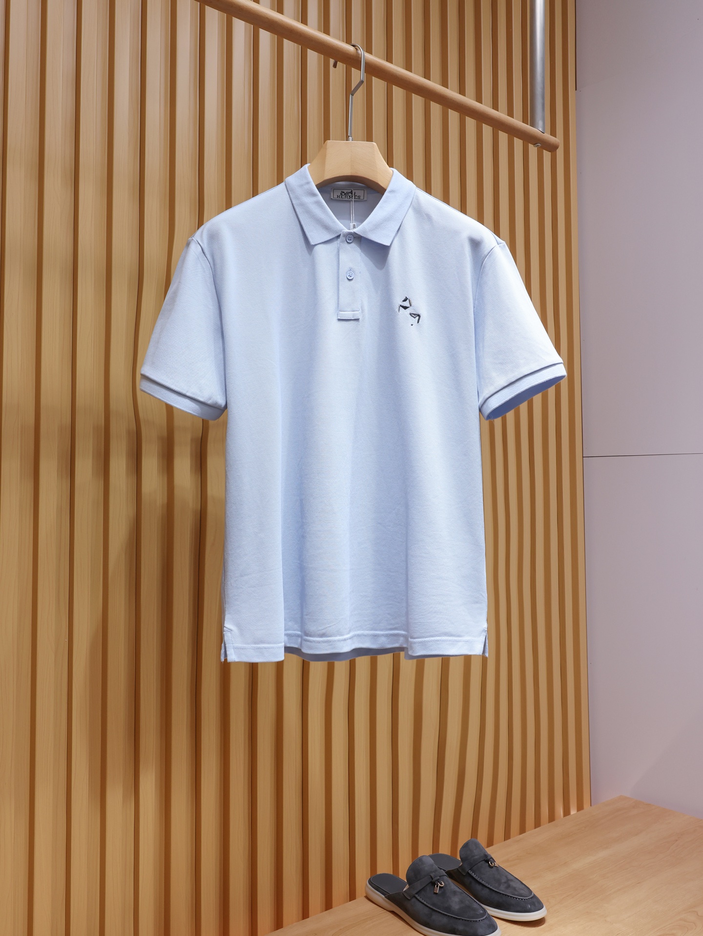 NO:822077,.Big H sky blue pony embroidery POLO shirt, stand-up collar short-sleeved T-shirt, Xinjiang long-staple cotton pique fabric, with fine and full texture, dry and breathable to the touch, good moisture absorption and perspiration, the upper body is not sweaty or sticky, and it has both comfort and stiffness.  The chest uses multi-color three-dimensional embroidery technology to restore the brand's iconic pony pattern. The stitching is delicate and neat, and the color is low-key and recognizable, which is just the right embellishment on the simple body. The classic lapel design, the neckline has been shaped many times, and it is not easy to collapse or curl after long-term wear. It is matched with shell buttons of the same color, and the texture is warm and high-end.  The cuffs and hem adopt double-line hemming technology, the routing is smooth and solid, and the side slit design improves wearing comfort and unrestricted movement. The tailoring is neat and fit, not tight nor loose, which can not only support the decent feeling of business and leisure, but also can be worn for daily relaxation, suitable for various scenes. Same style for men and women, blue, XS-XL size; 1-3CM error in flat measurement XS size: shoulder width 46, bust 106, clothing length 67, sleeve length 22.5  S code: Shoulder width 47 Bust 110 Clothes length 69 Sleeve length 23 M code: Shoulder width 48 Bust 114 Clothes length 71 Sleeve length 23.5 L code: Shoulder width 49 Bust 118 Clothes length 73 Sleeve length 24  If you weigh 150-165 pounds, choose size M; if you weigh 165-180 pounds, choose size L; if you weigh 180-200 pounds, choose size XL. Hermes - clothing, hermes, T-shirt, tees, t-shirt,19860909.大H天蓝色小马刺绣POLO衫 立领短袖T恤 新疆长绒棉珠地面料,肌理细腻饱满,摸上去干爽透气,自带良好的吸湿排汗性,上身不闷汗、不粘身,兼顾舒适与挺括感. 胸口采用多色立体刺绣工艺,还原品牌标志性小马图案,针脚细腻工整,配色低调又有辨识度,在简约的衣身上恰到好处地点缀.经典翻领设计,领口经过多次定型工艺,久穿不易塌、不易卷边,搭配同色系贝壳扣,质感温润高级. 袖口与下摆采用双线包边工艺,走线平整扎实,侧开叉设计提升穿着舒适度,活动不受限.剪裁利落合身,不紧绷也不宽松,既能撑起商务休闲的体面感,又能穿出日常的松弛感,适配多种场景. 男女同款,蓝色,XS-XL码； 平铺测量1-3CM误差 XS码:肩宽46胸围106衣长67袖长22.5 S码:肩宽47胸围110衣长69袖长23 M码:肩宽48胸围114衣长71袖长23.5 L码:肩宽49胸围118衣长73袖长24 XL码:肩宽50胸围122衣长75袖长24.5 女生选择XS码； 男生 135斤以下选择XS码；135-150斤选择S码； 150-165斤选择M码；165-180斤选择L码； 180-200斤选择XL码.,爱马仕-服装,hermes,T-shirt,tees，t-shirt,,Women's clothing
