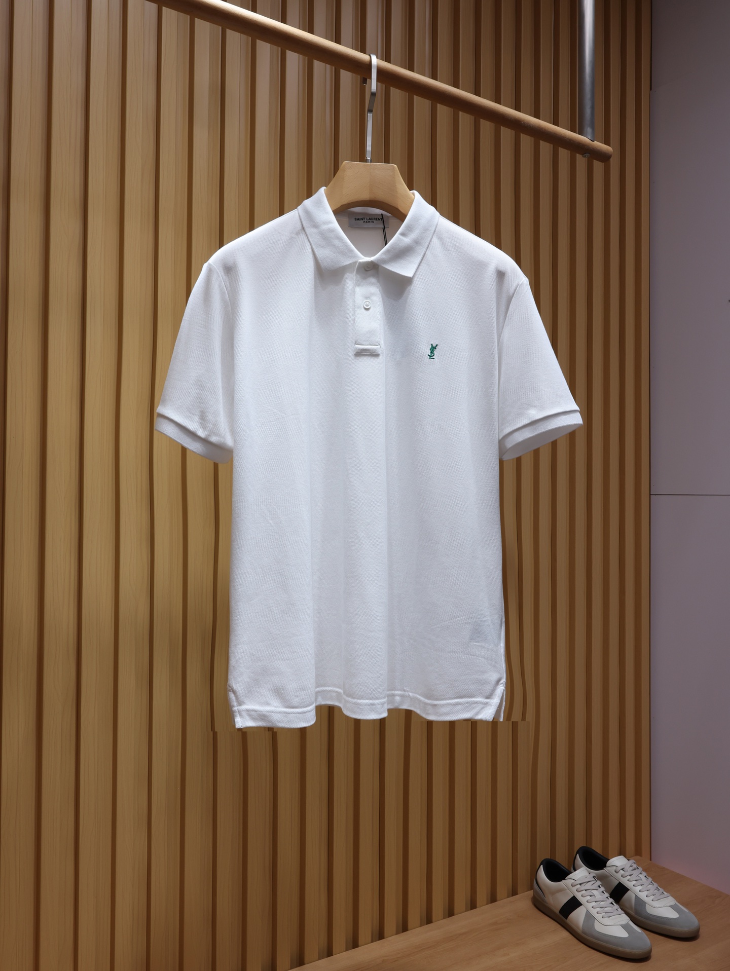 NO:935821,. YSL classic embroidered pique cotton breathable Polo shirt, a timeless French light luxury base ~ stand-up collar short-sleeved T-shirt. The entire piece is made of pure long-staple cotton pique fabric, with a fine three-dimensional honeycomb texture visible to the naked eye. The breathable mesh structure accelerates air circulation, does not stick to the body when you sweat, and does not become stuffy when worn for a long time. After pre-shrunk washing + liquid ammonia softening dual process treatment, it feels soft, waxy and crisp.  The classic three-dimensional YSL monogram embroidery on the left chest is divided into two-color exclusive color matching. The white model is paired with retro green embroidery label, which is refreshing and contrasting, gentle and durable; the black model is paired with off-white embroidery, which is full of dark and high-end texture. The high-density three-dimensional embroidery is neat and dense, does not prick the skin, and is not easy to fall off. The minimalist small label design abandons exaggeration and reveals the brand recognition in a low-key manner. Color: black, white, size XS-XL,, saint  laurent,T-shirt,tees,t-shirt,19860909. YSL经典刺绣珠地棉透气Polo衫 永不过时的法式轻奢基底~立领短袖T恤 整件采用纯正长绒棉珠地面料,细密立体蜂窝肌理肉眼可见,透气网眼结构加速空气流通,出汗不粘身、久穿不闷汗.经过预缩水洗+液氨柔化双重工艺处理,触感软糯挺括兼备. 左胸经典YSL交织字母立体刺绣,分双色专属配色白款搭配复古绿绣标,清爽撞色温柔耐看；黑款搭配米白刺绣,暗黑高级质感十足.高密度立体刺绣走线工整密实,不扎皮肤、不易脱线,极简小标设计摒弃浮夸,低调流露品牌辨识度. 颜色黑色 白色 尺码XS-XL,,saint laurent,T-shirt,tees，t-shirt,,Men's clothing