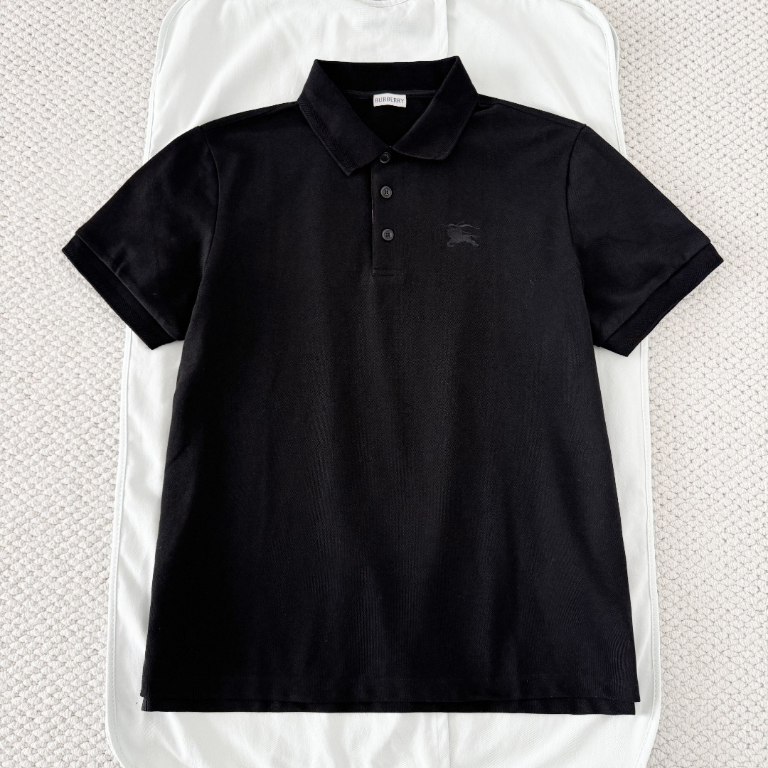 NO:823039,Original 1-1 development black BURBERRY horse embroidered short-sleeved POLO shirt fabric selection  Cotton is selected using pique knitting technology, and a concave and convex mesh texture is formed through a special knitted coil structure. Each group of coils are interlaced with each other to form a breathable 'small honeycomb' structure, forming a pique fabric with a weight of 220g/㎡  , taking into account both stiffness and drape. The pearl mesh structure forms a natural breathable channel, which can quickly discharge moisture from the body surface without causing sweating. At the same time, the pearl texture is delicate and layered, visually matte and low-key, and soft to the touch without sacrificing the muscles.  Embroidery process: Iron the front of the fabric flat in advance, accurately mark the embroidery position, install the embroidery frame into the machine, and align the center point of the pattern. Use high-saturation embroidery thread and pass it through a high-density filling needle. The stitches are fine and even, making the knight and war horse pattern clear and layered, visually embossed and not easy to deform. After finishing, the edges of the pattern are smooth, without hard edges, and there is no foreign body feeling when worn next to the skin. Detail 1  The edge of the neckline is embellished with a densely woven cotton thread of the same color, echoing the texture of the pique cotton fabric, making it visually more refined and tidy. After being set by high-temperature steam, it maintains a perfect lapel shape. It does not curl or collapse after long-term wear and washing. The collar always fits the neck and does not become loose when moving. Detail 2 uses high-transparent resin buttons with a smooth surface and no burrs. The center of the button is engraved with a letter logo, which is high-quality and wear-resistant. Detail 3  The plaid pattern at the placket adopts precise alignment cutting technology to ensure that the plaid lines at the splicing joints are naturally connected and without misalignment. The inner layer uses high-count cotton as the reinforcement layer, combined with the outer plaid fabric, and is shaped after multiple high-temperature presses to ensure that the placket will not roll or warp for a long time, and will always maintain a crisp and neat shape. Accessories One-to-one customized buttons One-to-one customized plaid decoration  SizeSMLXL,Burberry-clothing,burberry,burberry,T-shirt,19860909原版1-1开发 黑色 BURBERRY巴宝莉战马刺绣短袖POLO衫 面料选择 选用棉采用珠地针织工艺,通过特殊的针织线圈结构形成凹凸的网眼纹理,每一组线圈相互交错,构成透气的“小蜂巢”结构,形成克重达220g/㎡的珠地布,兼顾挺括感与垂坠性.珠地网眼结构形成天然透气通道,能快速导出体表湿气,不闷汗,同时珠地纹理细腻且富有层次,视觉上哑光低调,触感柔软却不失筋骨. 刺绣工艺 将面料前幅,提前熨烫平整,精准标记刺绣位置,将绣花框装入机台,对齐图案中心点.选用高饱和度绣线通过高密度填充针,针脚细密均匀,使骑士与战马图案轮廓清晰,层次分明,视觉上有浮雕感,不易变形.后整理之后,图案边缘平滑,无硬边,贴肤穿着无异物感. 细节1 领口边缘采用同色棉线密织纹理点缀,与珠地棉面料纹理呼应,视觉上更精致整洁.经高温蒸汽定型之后,保持完美翻领形态,久穿、久洗不卷边、不塌陷,活动时领口始终贴合颈部,不松垮 细节2 采用高透树脂纽扣,表面光滑无毛刺,纽扣中心刻有字母标识,质感高级且耐磨. 细节3 门襟处的格纹采用精准对位裁剪工艺,确保拼接处的格纹线条自然衔接、无错位.内层采用高支数棉料作为加固层,配合外层格纹面料,经过多次高温压烫定型,确保门襟长期穿着不翻卷、不起翘,始终保持挺括利落的形态. 辅料一比一定制纽扣  一比一定制门襟格纹装饰 SizeSMLXL,博柏利-服装,burberry,burberry,T-shirt,,Women's clothing