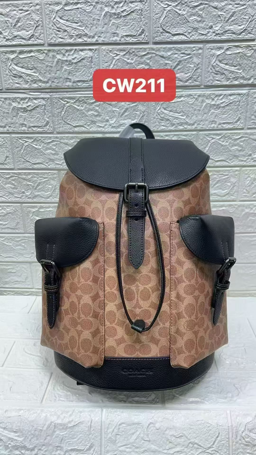 COACH men's PVC and leather backpack, fashionable and casual, simple and trendy, genuine product CW211. Size 31×47×15 cm. Perfect for stylish men going on a road trip. The color scheme is sophisticated and the design is youthful. The flap design is modern and not dull. The large pockets on both sides provide ample storage space. The metallic buckle adds a touch of masculinity. Made of top-grain leather, showcasing high-quality craftsmanship and elite style. image 1