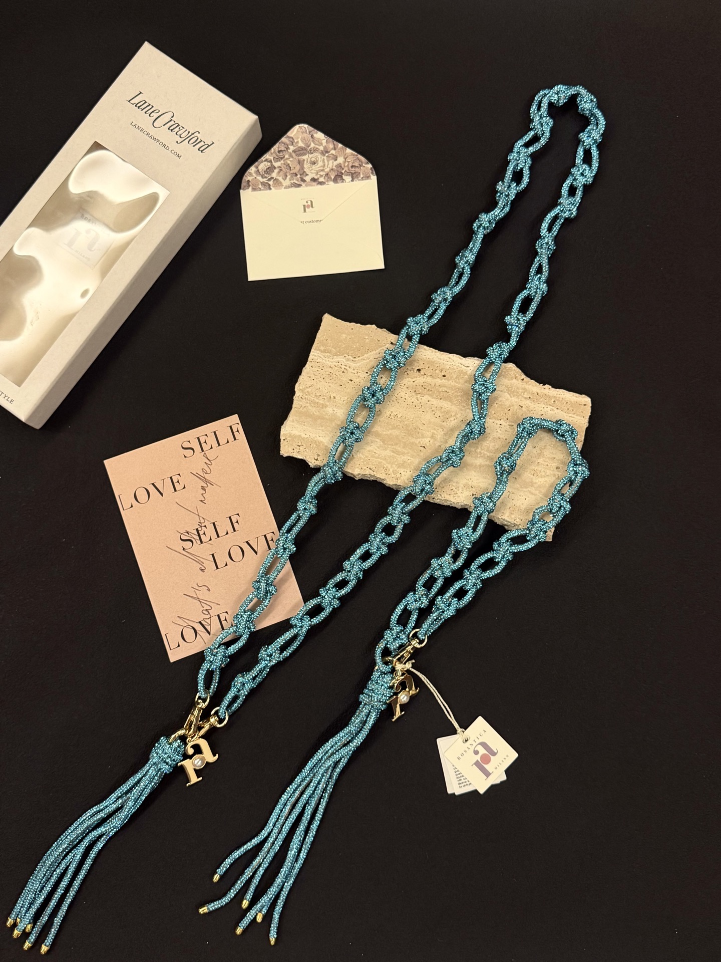 NO:919150,Capri island blue｜Carry Italian summer in your hand Rosantica handmade crystal mobile phone lanyard｜Bag lanyard｜The turquoise lake blue that falls in love with you at a glance Hand-knotted woven chain, with smart tassel pendant It has a fine luster in the sun, not tacky at all Exquisite H pearl letter metal small tag, full of details It can not only be used as a mobile phone lanyard, it can also be used as a bracelet or small bag pendant when removed  One thing has multiple uses, and the price/performance ratio is perfect. Vacation｜Afternoon Tea｜Daily shopping, you can take great photos anytime. Spring and summer atmosphere accessories, no longer afraid of dropping your phone when you go out #Rosantica #手机chain #Summer accessories #Italian accessories #Exquisite small things,,bracelet19860909卡普里海岛蓝｜把意大利夏日拎在手上 Rosantica手工水晶手机挂绳 ｜包包挂绳｜ 一眼沦陷的松石湖蓝色 手工打结编织链条,自带灵动流苏吊坠 阳光下细碎的光泽感,完全不会俗气 精致H珍珠字母金属小吊牌,细节满分 不是只能当手机挂链 拆下来还可以做手链、小包挂饰 一物多用,性价比直接拉满 度假｜下午茶｜日常逛街随手拍都巨出片 春夏氛围感配饰,出门再也不怕摔手机 #Rosantica #手机链 #夏日配饰 #意大利配饰 #精致小物,,bracelet,accessory