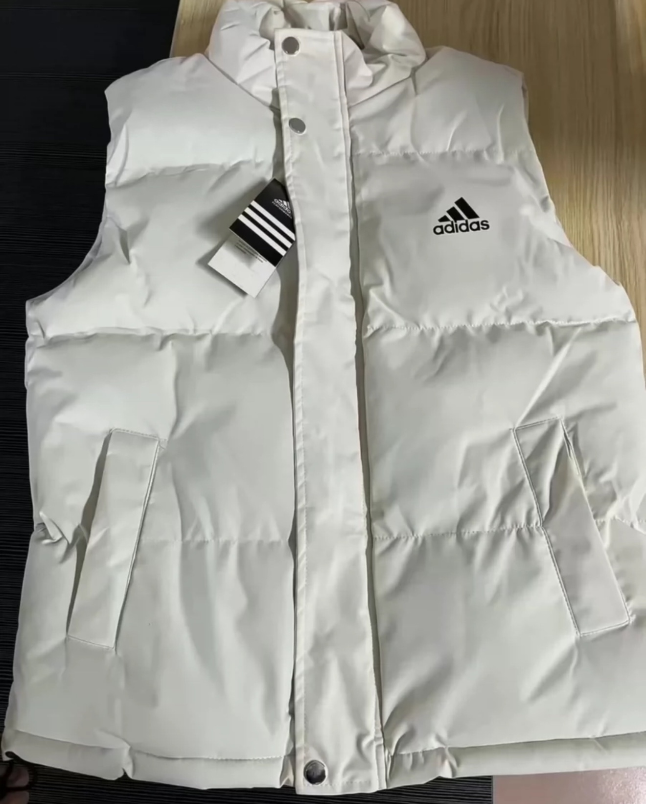 供货价:55💰『官网羽绒棉马甲』百搭不腻版,满足各种身材中空棉,原包装+原吊牌  
三叶草三色☯️填充物充实高版本adidas/阿迪三角标logo棉马甲 暖冬，手塞棉的温柔拥抱
【品牌】:adidas
【尺码】: M-5xl
【颜色】: 黑色，米白色，藏蓝色
【面料】:  尼龙 ，
M肩宽41胸围106 衣长63（60-80斤）
L肩宽43胸围110衣长65（80-100斤）
xl肩宽45胸围114衣长67（100-120）
2xl肩宽47胸围118衣长69（120-140）
3xl肩宽49胸围122衣长71（140-160）
4xl肩宽51胸围126衣长73（160-180）
5xl肩宽53胸围130衣长75（180-200）