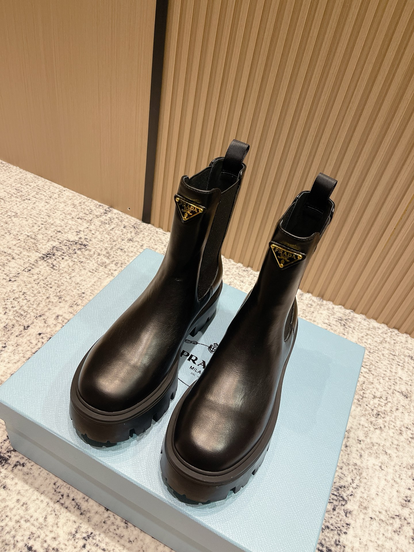 NO:558723,The top version of Prada 25Fw's latest thick-soled short boots is the same as the star's triangular label buckle, one-leg thick-soled and elevated motorcycle-style elastic band short boots. The combination of classic lines and modern elements defines this style of short boots. Shiny cow leather highlights the lines of the shoes, with thick soles, and is decorated with the iconic enameled triangular metal logo.  This shoe is equipped with a distinctive round toe and a thick rubber sole that injects a modern look into classic loafers. The enameled triangular metal logo decoration highlights the brand's style. The retro glossy leather commonly used in exquisite shoes has been reinterpreted in the Prada series to create a unique and modern mix and match design. The upper is cowhide/open edge beads. The lining is sheepskin. The sole is original open mold infusion process TPU outsole. The sole is 5cm thick.   Size 35-39 (40.41 custom-made, non-refundable), boots, prada, prada, loafers, boots, cowhide, sheepskin19860909顶级版本 Prada 普拉达 25Fw最新厚底短筒靴 明星同款三角标扣一脚蹬厚底增高机车风松紧带短靴 经典线条与现代元素相结合,定义了此款风格多样的短靴.亮面牛皮革突显鞋履线条,搭配厚实鞋底,并饰以标志性的涂珐琅三角形金属徽标. 这款鞋履配有鲜明的圆形鞋头,橡胶厚底为经典乐福鞋注入现代外观,涂珐琅三角形金属徽标装饰彰显品牌格调.惯用于精美鞋履的复古亮面皮革经Prada系列重释,打造别具现代气息的混搭设计. 鞋面牛皮/开边珠 内里垫脚羊皮 鞋底原版开模灌注工艺TPU大底 底厚5cm 码数35-39（40.41定做不退换）,靴子,prada,prada,loafers,boots,cowhide,sheepskin,Women's Shoes