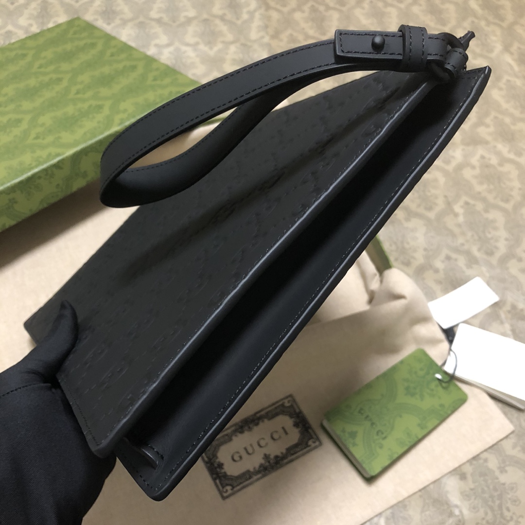 一款以黑色橡胶效果皮革打造的男士手拿包闪亮登场，全新材质为这款设有一个腕带提手的时尚单品带来视觉上的全新