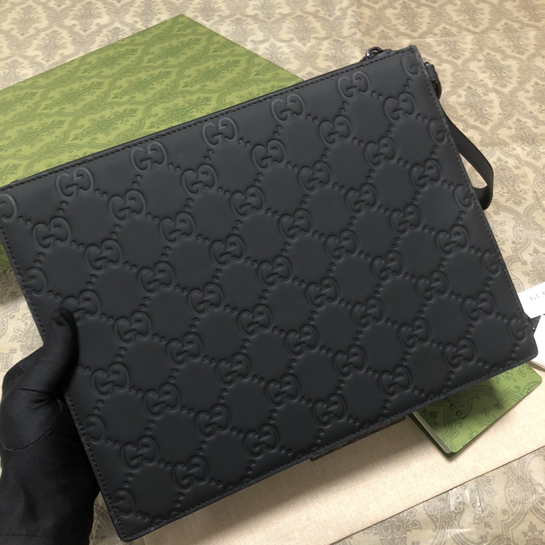 一款以黑色橡胶效果皮革打造的男士手拿包闪亮登场，全新材质为这款设有一个腕带提手的时尚单品带来视觉上的全新