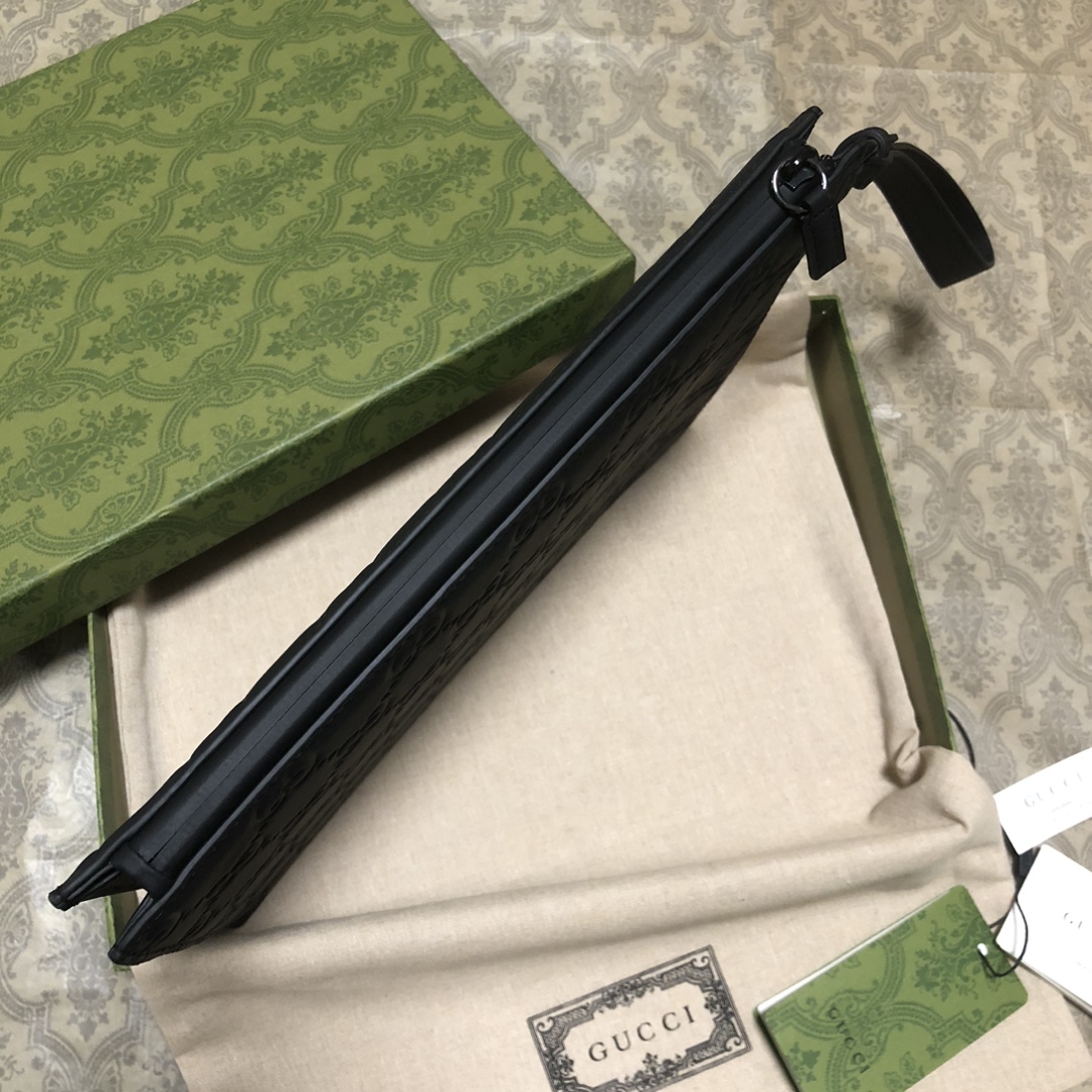 一款以黑色橡胶效果皮革打造的男士手拿包闪亮登场，全新材质为这款设有一个腕带提手的时尚单品带来视觉上的全新