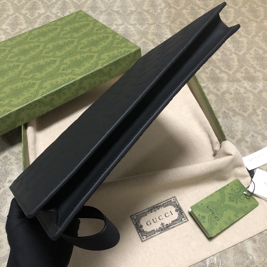 一款以黑色橡胶效果皮革打造的男士手拿包闪亮登场，全新材质为这款设有一个腕带提手的时尚单品带来视觉上的全新