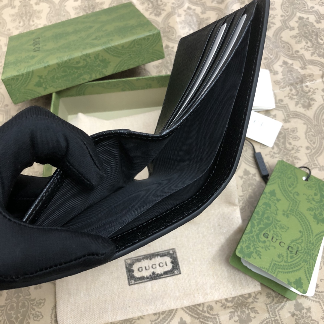 此款短钱包，配以醒目的标志性双 G 金属配件。采用热压小牛皮制作，以获得野猪猪皮效果，营造织纹外观。款号