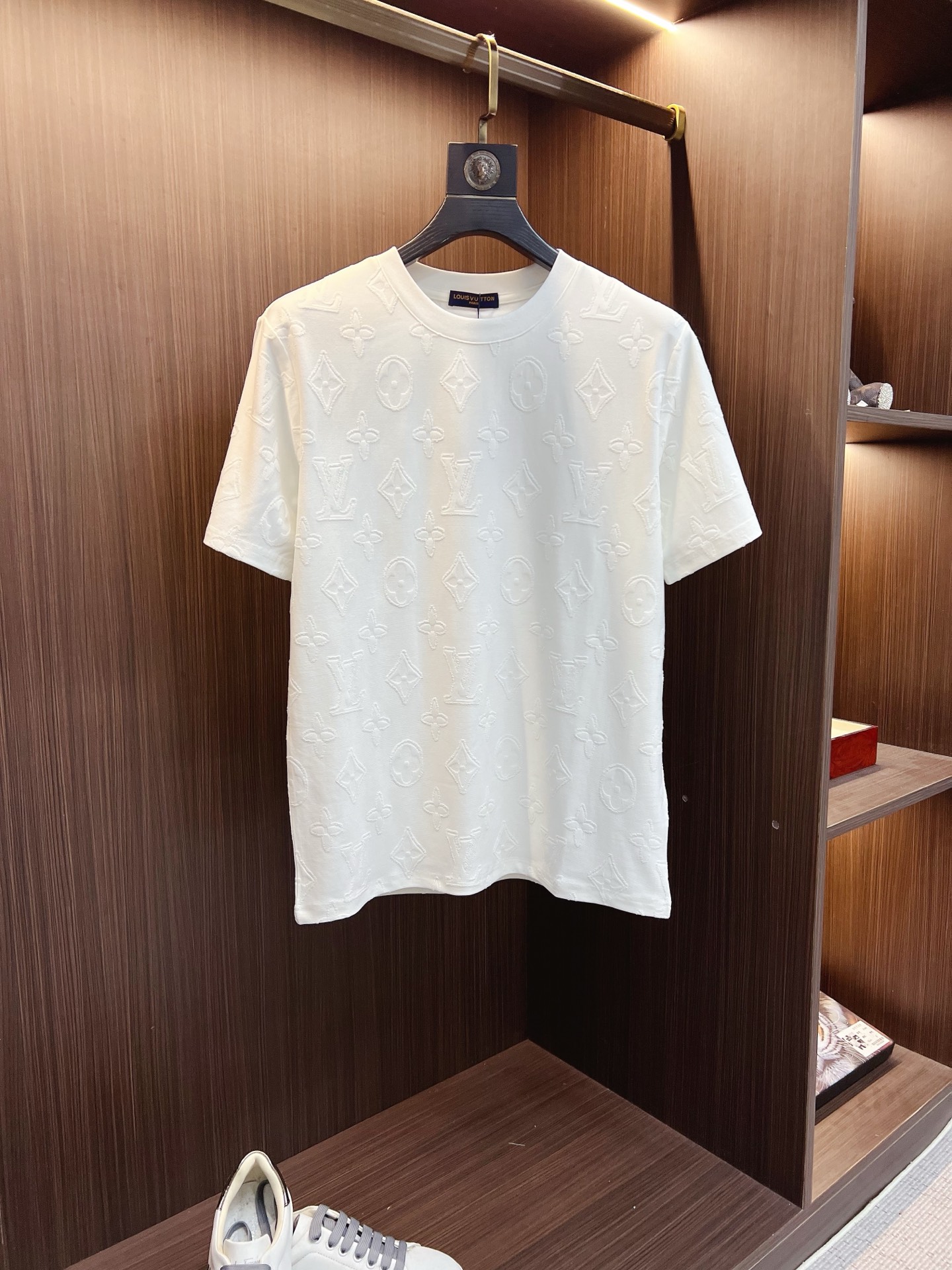 NO:859226,1v 26ss new product full-print old flower short-sleeved T-shirt. This white T-shirt uses special jacquard technology to combine the classic LV  The presbyopia pattern is three-dimensionally presented on the surface of the fabric. The fabric has been specially treated to present a delicate concave and convex texture. Each letter and pattern is clear and three-dimensional, with a rich touch. The round neck design fits the neck line, neatly cut, and the overall silhouette is simple and elegant. The jacquard process integrates the pattern and the fabric through precise weaving control, which not only maintains the visual layering but also ensures wearing comfort.  The sewing lines on the body are even and neat to ensure a solid structure and not easily deformed. The hem and cuffs are smooth and neat, and the edges are clean and neat, reflecting the exquisite clothing craftsmanship. The overall design is low-key yet luxurious, combining classic presbyopic elements with modern tailoring, which is not only suitable for daily wear, but also demonstrates quality and taste in the details. The overall routing is straight and delicate, the fabric is comfortable and soft, and the colors are consistent and without color difference.  It can be matched with the same style to create a fashionable look, and can be used in various occasions. Customized accessories, complete with three standards, same style for men and women!  SizeS-2XL,,louis vuitton,T-shirt,tees,t-shirt,198609091v 26ss新品 满印老花短袖T恤 这件白色 T 恤采用特殊的提花工艺,将经典的 LV 老花图案立体呈现在面料表面.面料经过特殊处理,呈现出细腻的凹凸纹理,每一个字母与图案都清晰立体,触感丰富.圆领设计贴合颈部线条,剪裁利落,整体廓形简约大方.提花工艺通过精确的织法控制,使图案与面料融为一体,既保持了视觉上的层次感,又确保了穿着的舒适度.衣身的车缝线均匀工整,确保结构牢固且不易变形.下摆与袖口的处理平滑整齐,边缘干净利落,体现出精湛的制衣工艺.整体设计低调而不失奢华,经典的老花元素与现代剪裁相结合,既适合日常穿搭,又能在细节中彰显品质与品味.整体走线平直细腻,面料舒适柔软,颜色一致无色差 能与同款搭配营造时尚造型,驾驭各种场合,定制辅料,三标齐全,男女同款！ SizeS-2XL,,louis vuitton,T-shirt,tees，t-shirt,,Men's clothing