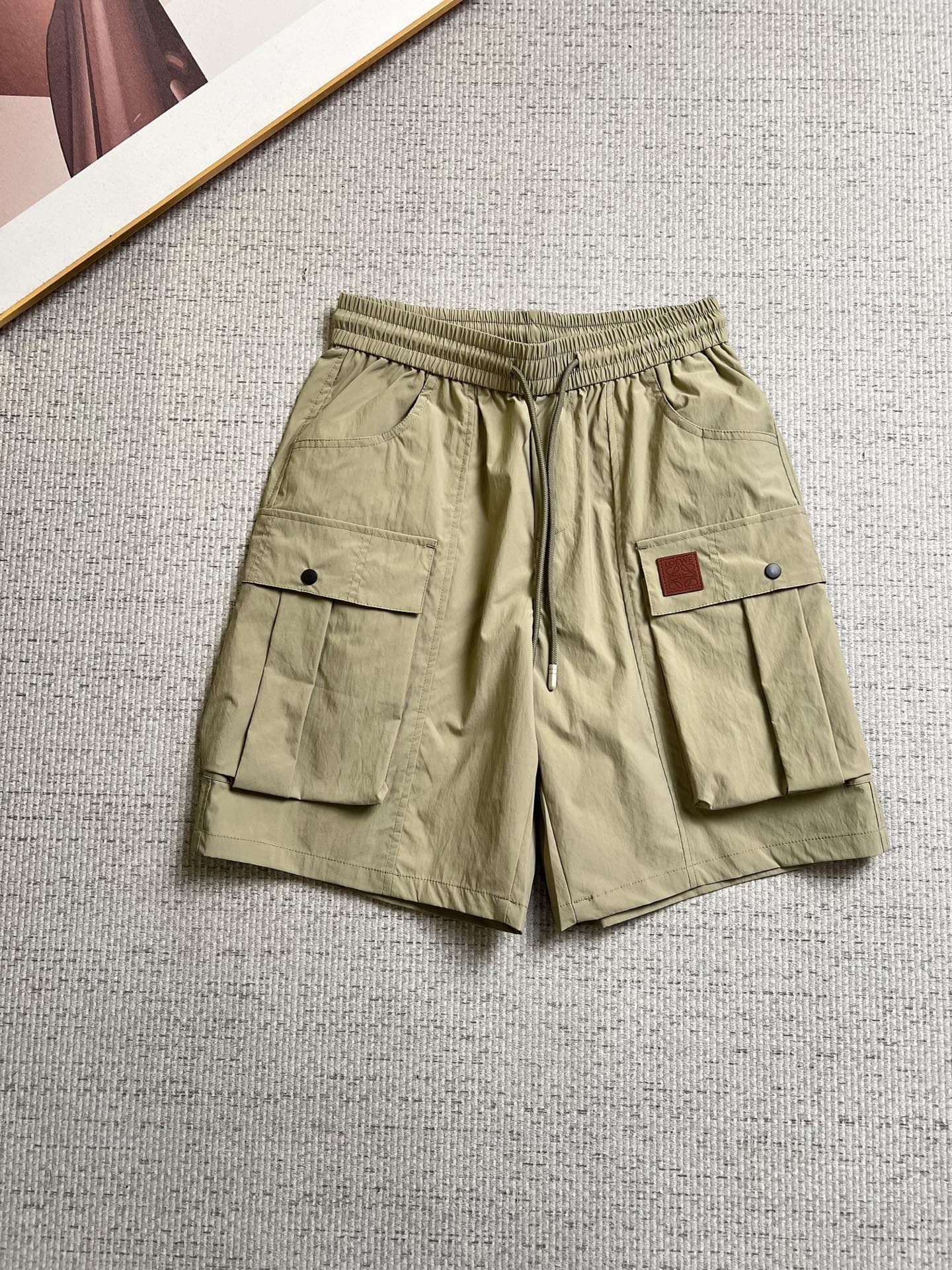 NO:937345,Loewe 26ss new summer men's casual work shorts, advanced custom-made summer-specific technical quick-drying breathable fabric, with high breathability and comfort, impeccable details, customized development of accessories, what you see is what you get, reflecting high quality. It feels delicate and soft!  Three-dimensional cutting, simple and fashionable, and the upper body shape is awesome!  Code number 29–38,,loewe,shorts,19860909罗意威 26ss夏季新款男士休闲工装短裤 高级定制夏季专用科技速干透气面料 透气舒适度高,细节无可挑剔,辅料定制开发,所见即所得,体现高品质.手感细腻柔软！立体裁剪,简单时尚,上身版型超赞！码数29–38,,loewe,shorts,,Men's clothing