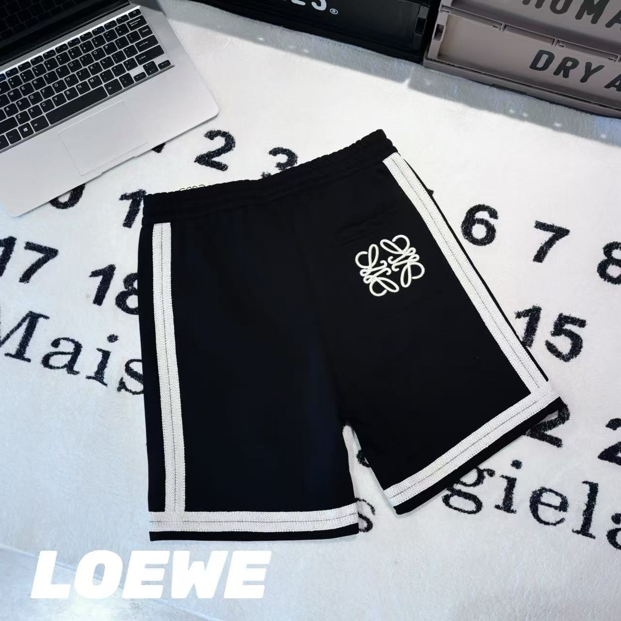 發75💰

-LOEWE罗意威刺绣拼接色织织带短裤 男女同款

-面料：采用原版一比一面料。

-辅料：原版拆解开发，一比一定制的小标，领标，水洗，吊牌，五金等等。

-工艺：原版分解，从裁剪，拼接，到缝制工艺完全原版一比一。

-颜色：黑色

-尺码：S M L XL
      裤长     腰围     臀围     推荐尺码
S     58       76        108      120斤内
M   59       80         112      140斤内
L     60       84         116      160斤内
XL   61       88         120      190斤内   