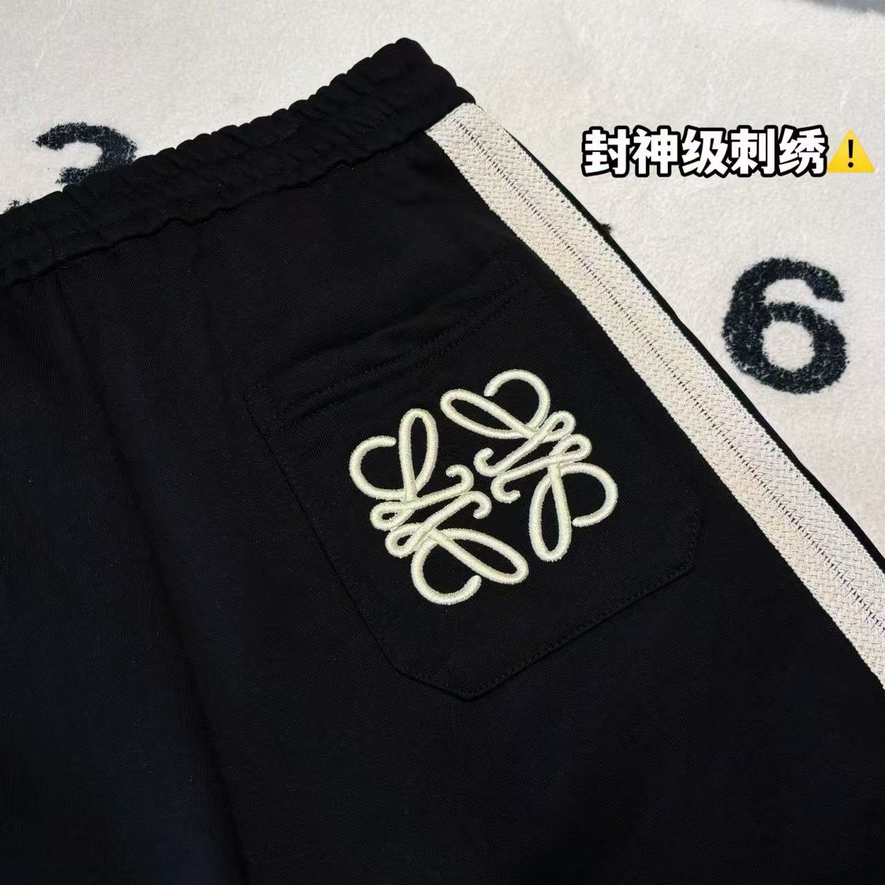 發75💰

-LOEWE罗意威刺绣拼接色织织带短裤 男女同款

-面料：采用原版一比一面料。

-辅料：原版拆解开发，一比一定制的小标，领标，水洗，吊牌，五金等等。

-工艺：原版分解，从裁剪，拼接，到缝制工艺完全原版一比一。

-颜色：黑色

-尺码：S M L XL
      裤长     腰围     臀围     推荐尺码
S     58       76        108      120斤内
M   59       80         112      140斤内
L     60       84         116      160斤内
XL   61       88         120      190斤内   