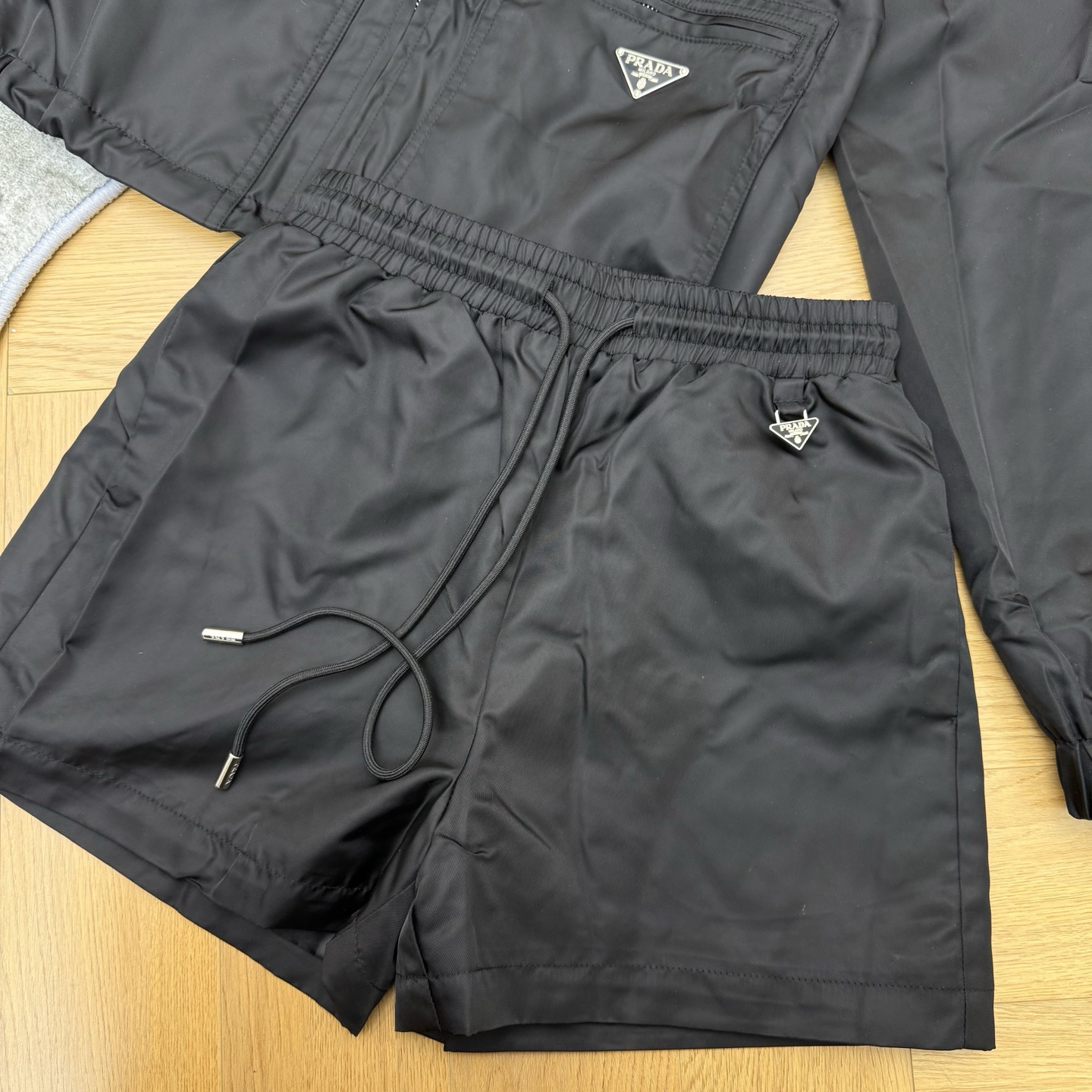 Prada26早春休闲尼龙套装，经典连帽+双拉链口袋设计，利落又藏满细节，三角徽标点缀低调显贵，顺滑尼龙