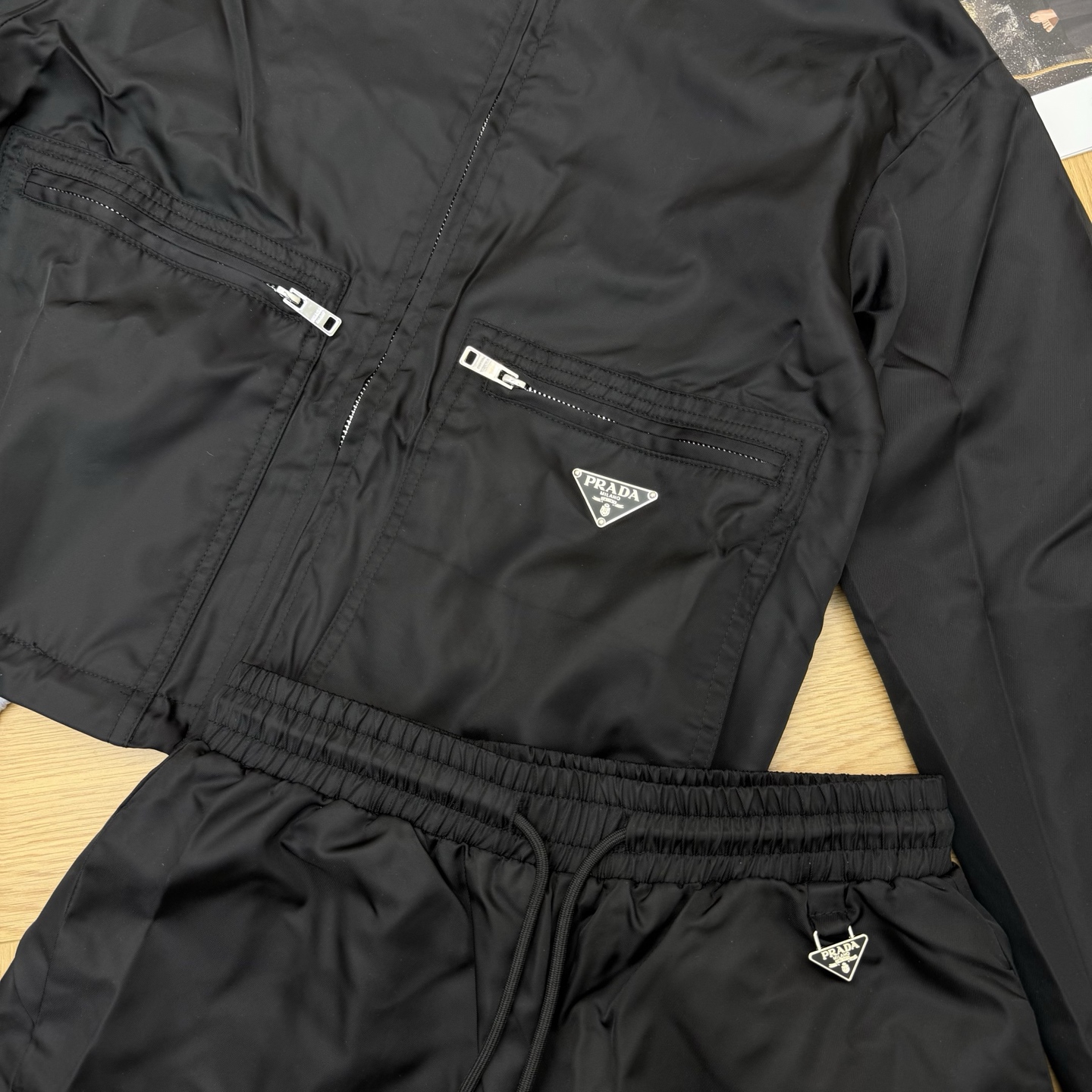 Prada26早春休闲尼龙套装，经典连帽+双拉链口袋设计，利落又藏满细节，三角徽标点缀低调显贵，顺滑尼龙