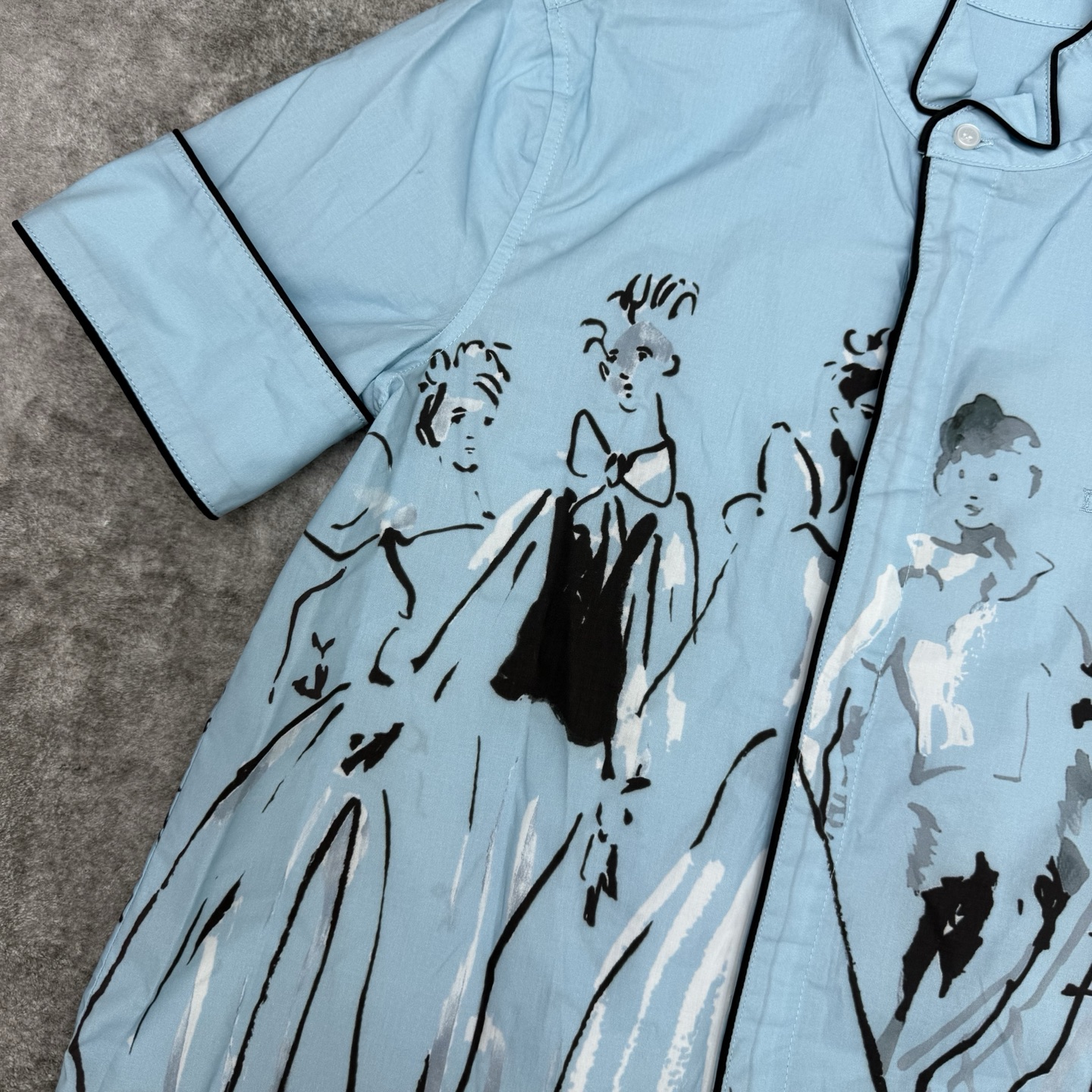 D家 26夏季新款 蓝色印花短袖衬衫 采用棉质面料立领+黑色滚边细节精致 黑色线条人物图案 艺术感满满 