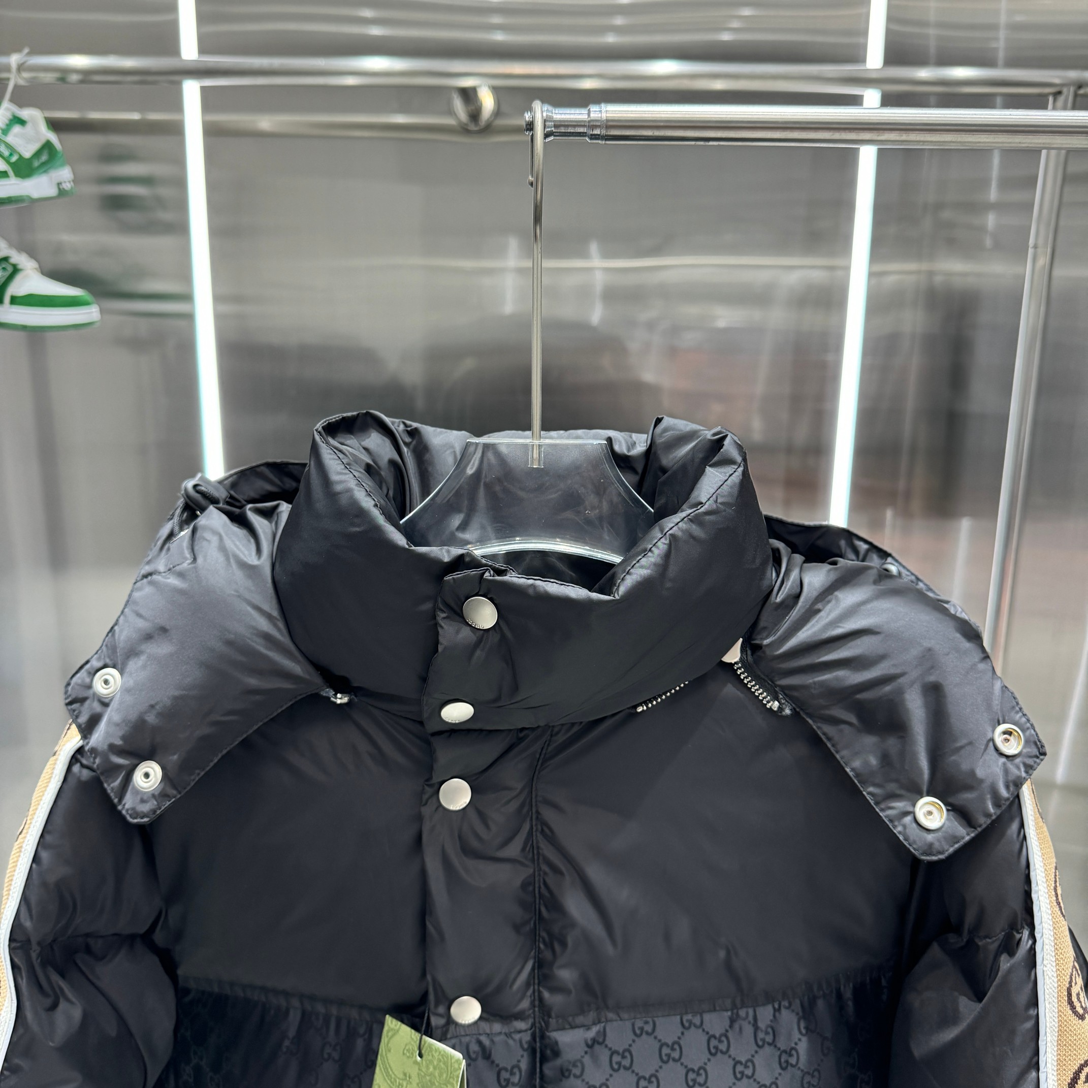 P400 Gucci/古驰反光织带羽绒服 男女同款2024GG织带新元素暗双G缝
黑色立领羽绒大衣，采用尼龙塔夫绸绗设计，衣身缀有同色徽标。可拆卸式抽绳兜帽，正面隐藏式双向拉链，按扣前襟，腰部贴边袋。填充: 90%鹅绒，10% 羽毛
尺码：M L XL XXL