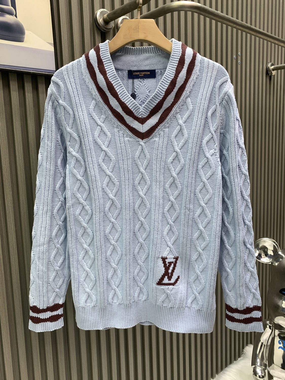 NO:622224,Louis Vuitton Louis Vuitton 25* new autumn and winter cable knit sheep wool and mohair V-neck pullover This cable knit V-neck sweater is made of fine mohair and sheep wool, making the scalloped hem of the sleeves contrast with the wavy intarsia lines on the cuffs and collar. Contrast color 1V intarsia hem on the left to inject a college atmosphere into the early spring look. Made of blended wool yarn  30 wool 70 acrylic dyed yarn. The process is complex and needs to be divided into pieces. This style uses 7-needle Juxin woven fabrics. 9 yarn feeders are needed to hang the logo on the front. The whole thing needs to be moved to twist the rope. It is easy to explode holes at the intersection of the twisted ropes. The coffee-colored part of the yarn is mohair. It takes a long time to adjust the machine. The needles at the bottom of the sleeve clips are all edged. It increases the loom time and sewing time. Because it is hung with wool, the coffee-colored thread is clamped on the edge.  The thread needs to be drawn out, and due to the characteristics of mohair, there will be hair loss when drawing out the thread. It needs to be manually removed little by little, which is very time-consuming. Customized accessories. Complete with three standards. Same style for men and women. Louis vuitton, louis vuitton, alexander wang19860909Louis Vuitton路易威登 25*秋冬新款绞花针织 绵羊毛和马海毛 V 领套头衫 本款绞花针织 V 领衫取材细腻马海毛与绵羊毛令衣袖的扇形下摆与袖口及衣领的 波浪嵌花线条相映成趣 撞色 1V 嵌花栖身左侧下摆 为初春造型注入学院气息 采用混纺羊毛纱线 30羊毛70腈纶定染纱线 工艺复杂需分/件 此款用7针巨鑫机织片 前幅logo挂毛处需用到9把纱嘴 全件搬针扭绳 扭绳交叉处易爆洞 全件咖色部分纱线为马海毛 调机时间长 袖子夹底处加针全部为有边 增加了织机时间和缝合时间 logo处因为是挂毛做法 咖色线夹在边上 需抽线 而且由于马海毛的特性 抽线时会出现掉毛现象 需手工一点一点将杂毛去掉 非常耗时间 定制辅料 三标齐全 男女同款,,louis vuitton,louis vuitton,alexander wang,Men's clothing