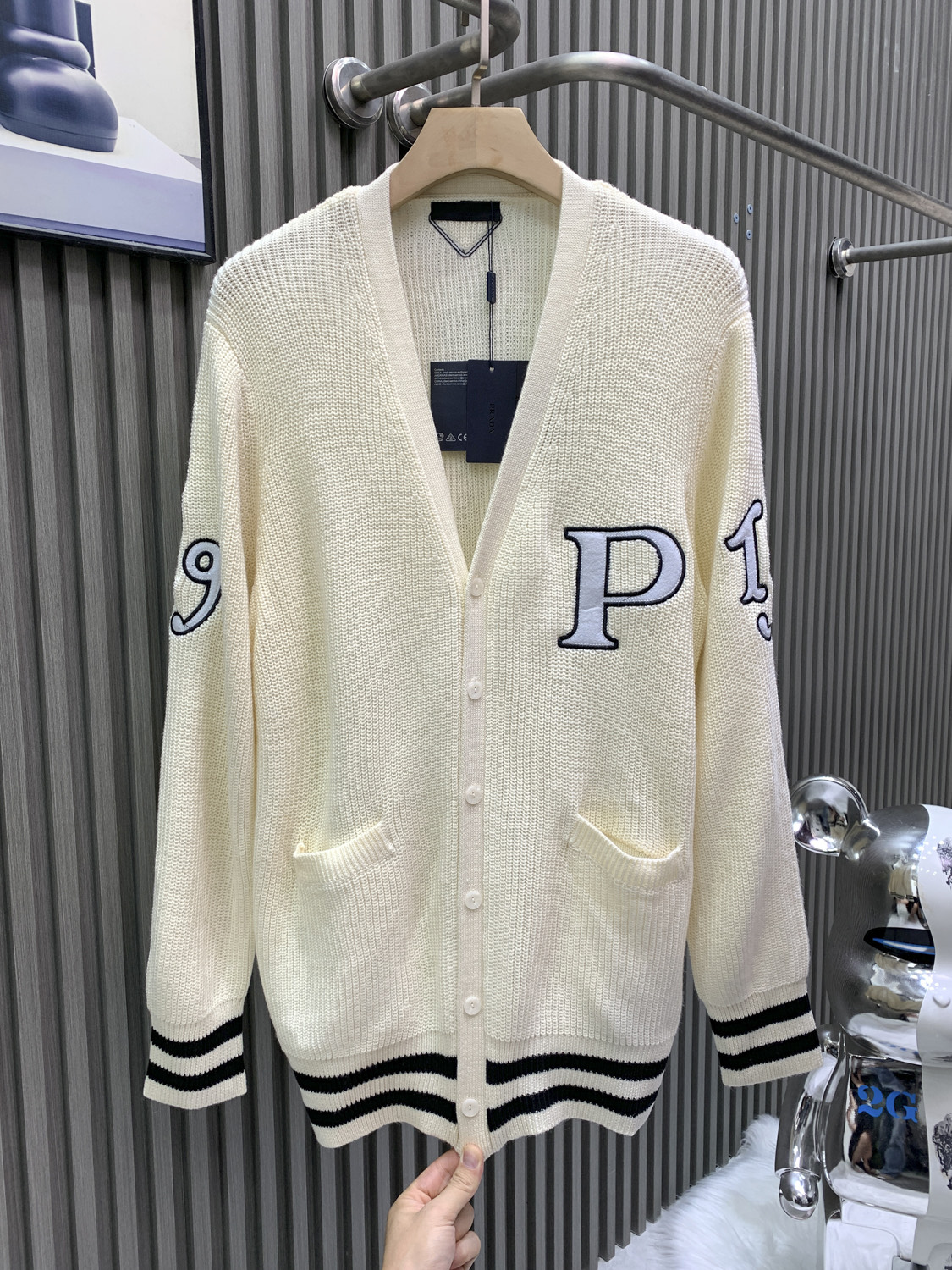 NO:622242,PRADA [PRADA] Prada 25ss1913 embroidered cardigan is made of woolen bulked cotton yarn. Compared with ordinary cotton, bulked cotton has a fluffy and soft feel. The pattern patch of 1319 and P is custom-made by a professional imported Tajima embroidery machine. The pattern is modified many times by the pattern maker and then stitched twice by a professional marking machine. This style is made of 70.0 sheep wool and 30.0 cashmere. The whole piece has a long-sleeved design.  Rib knitting is used to decorate the edges of the collar. It is paired with a dropped shoulder design. Rib knitting cuffs and hem. The back triangle attachment is made of high-proportion wool yarn. The flat knitting machine uses a coarse needle machine that is different from the large body for knitting. Professional flat machines are used for sewing. The upper body of the clothes is upright. It is skin-friendly and does not tie the body. The buttons are pressed with natural horn, prada, prada, alexander wang19860909PRADA普拉达【PRADA】普拉达25ss1913刺绣开衫 采用粗纺膨体棉纱 与普通棉相比膨体棉会有种蓬松柔软的手感 版型蓬松 1319和P的图案贴布经过专业进口田岛刺绣机器进行订做而成 图案由制版师修改多次 再由专业打标机两次缝合 此款采用70.0绵羊毛 30.0山羊绒 整件做长袖设计 罗纹针织做衣领边边修饰 搭配落肩款设计 罗纹针织袖口与底边 后面三角附件采用高比例羊毛纱线 横机采用与大身不同的粗针机器进行针织 专业平车进行缝合 衣服上身立挺 亲肤不扎身 扣子采用天然牛角压制而成,,prada,prada,alexander wang,Men's clothing