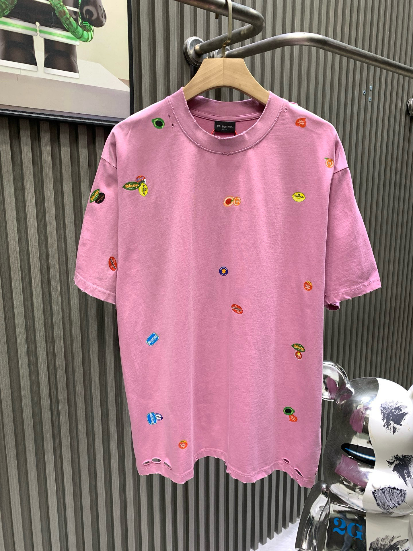 NO:743663,Balenciaga Balenciag* 2025 Fruit Logo Printed Short Sleeves Made of 280g 40S fine plain weave cotton. The front, back and sleeves are decorated with art prints. High-quality environmentally friendly elastic glue not only has good printing performance and adhesion, but also ensures the clarity and color brightness of the printed pattern. It has excellent elasticity and environmental protection performance. It can form long-lasting bright printing effects on various fabrics. Utilizes high-precision plate-making equipment and materials.  Printing technology that transfers customized dot patterns to fabrics. Because the distribution of dots is very dense, the printed patterns have extremely high clarity and resolution. The process of using digital printing equipment to spray white ink directly onto the fabric for printing. The ink droplets form dense dots on the fabric to form a complete pattern. The printing effect is bright and colorful, the pattern is delicate, and the layering is strong. The garment is made by frying yarn after embroidery. The fabric is dyed by stone grinding and the garment is continuously immersed in the dye and tumbled. The fabric is slightly whitened after sanding.  Change the color of the original fabric to present a nostalgic color with different shades of light and dark. Classic loose H drop shoulder style. Round neck with smooth rib stitching. Inner strip at the back neckline to prevent deformation. Elastic inserts are embedded in the internal seams to prevent shoulder seams from deforming after multiple washes. Special machine-edited double topstitching is used on the cuffs and hem, balenciaga, balenciaga, T-shirt,19860909Balenciaga巴黎世家 Balenciag* 2025水果标印花短袖 采用40S精棉平纹纯棉280g 正面背面和衣袖饰以艺术作品印花 优质的环保弹力胶浆不仅具有良好的印刷性能和附着力 还能确保印花图案的清晰度和色彩鲜艳度 优良的弹性和环保性能 能够在各种织物上形成持久鲜艳的印花效果 利用高精度的制版设备和材料 将定制的网点图案转移到织物上的印花技术 由于网点的分布非常密集 因此印刷出的图案具有极高的清晰度和分辨率 使用数码印花设备将白色墨水直接喷射到织物上进行印花的工艺 墨滴在织物上形成密集的网点 从而构成完整的图案 印花效果色彩鲜艳 图案细腻 层次感强 成衣绣花后进行炒纱工艺制作而成 通过石磨的方式对面料进行染色加成衣不断地浸入染料中翻滚 炒砂后面料轻微泛白 改变原面料颜色呈现出深浅一明暗不同的怀旧色彩 经典宽松H落肩版型 顺色罗口拼接圆领 后领口内贴条防止变形 内部做缝处以弹力嵌条的嵌入 防止多次穿洗后肩缝走形 袖口、下摆采用专机辑双明线收边,,balenciaga,balenciaga,T-shirt,,Men's clothing