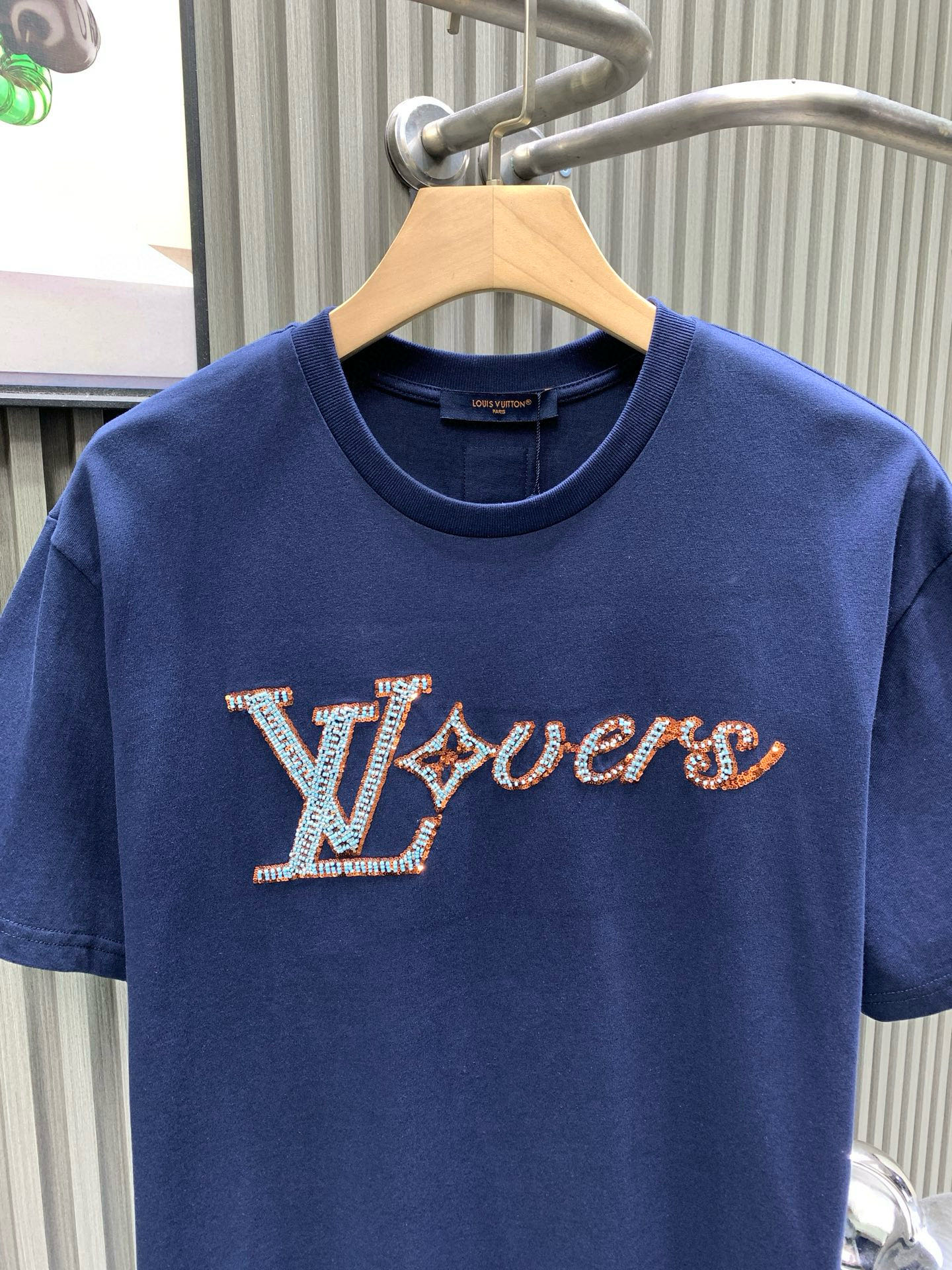 💰120🀄️   Louis Vuitton路易威登
1V 2025新款手工珠刺绣短袖T恤
40S纯棉平纹100%纯棉面料 280g
本款T恤取材柔软棉料  以串珠刺绣抒写1V Lovers 标识  可为日常造型注入雅致气息
面料透气性和透汗性好  可以吸附人体皮肤上的汗水和微汗  夏季穿着不会粘贴人体比较舒适
真正达到透气  吸汗效果
亮片绣花也被称为珠片刺绣或亮片绣
是绣花机的一个种类  选用质地较硬、表面平整且光洁度高的材料沿指定方向将亮片放置在织物上
同时绣针在亮片中心位置刺入织物以固定亮片位置
串珠部分有凸出的立体面
形成了饱满浮突有起伏效果  增添了图案的立体质感串珠都通过原版对色定染  打造渐变串珠效果
成色效果饱和明亮  铺满并做到原效果
颗粒数量分明  整体出立体效果出众